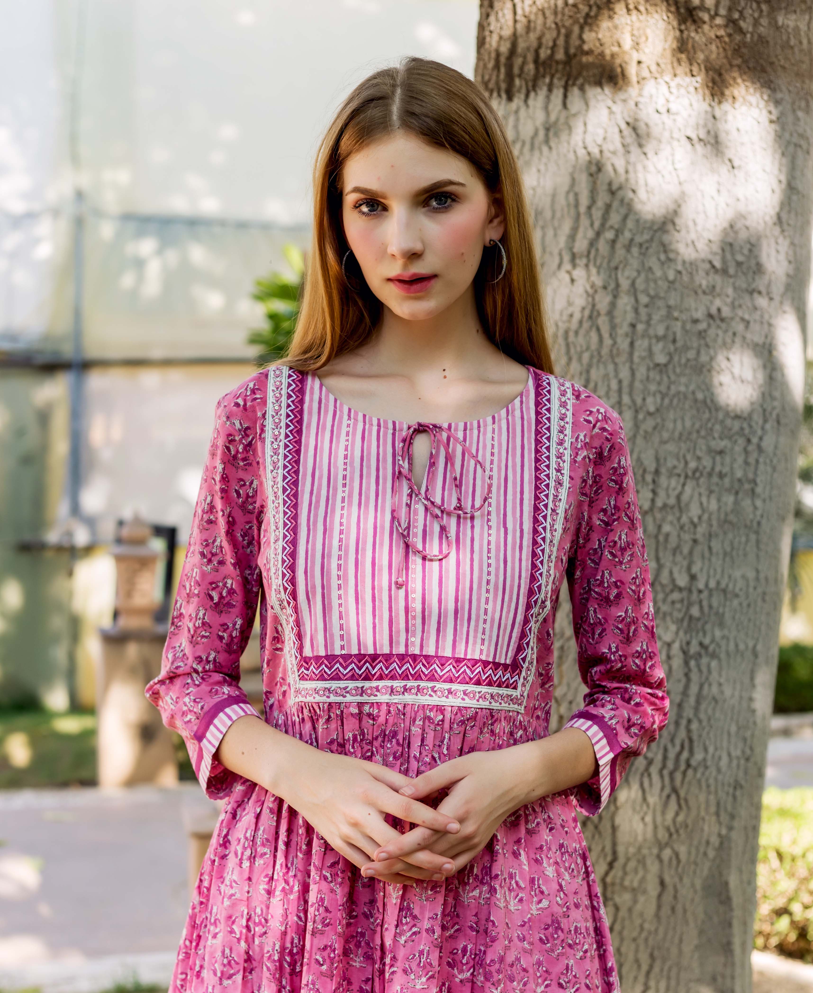Pink hand-block printed cotton kurta on model, featuring floral body and striped yoke.