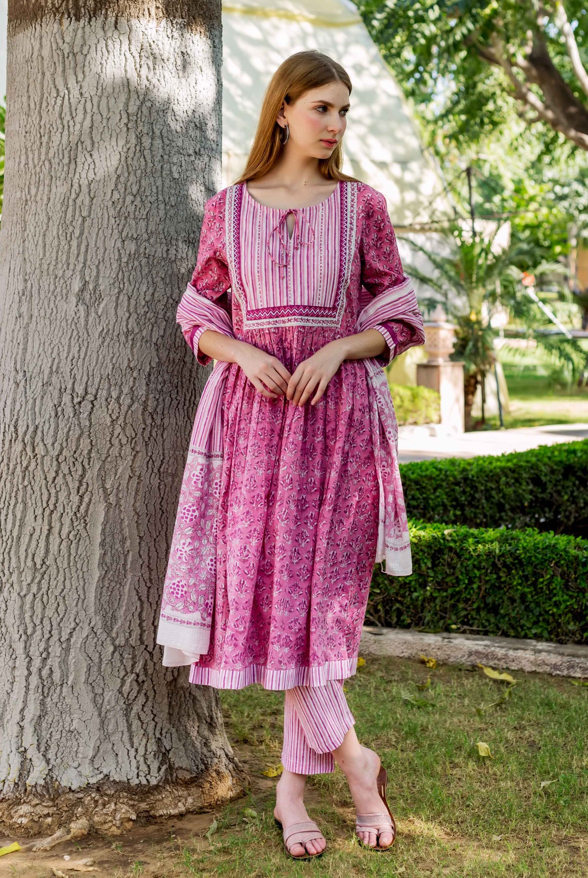 Pink floral hand-block-printed A-line kurta, striped yoke, matching pants, and dupatta on model.