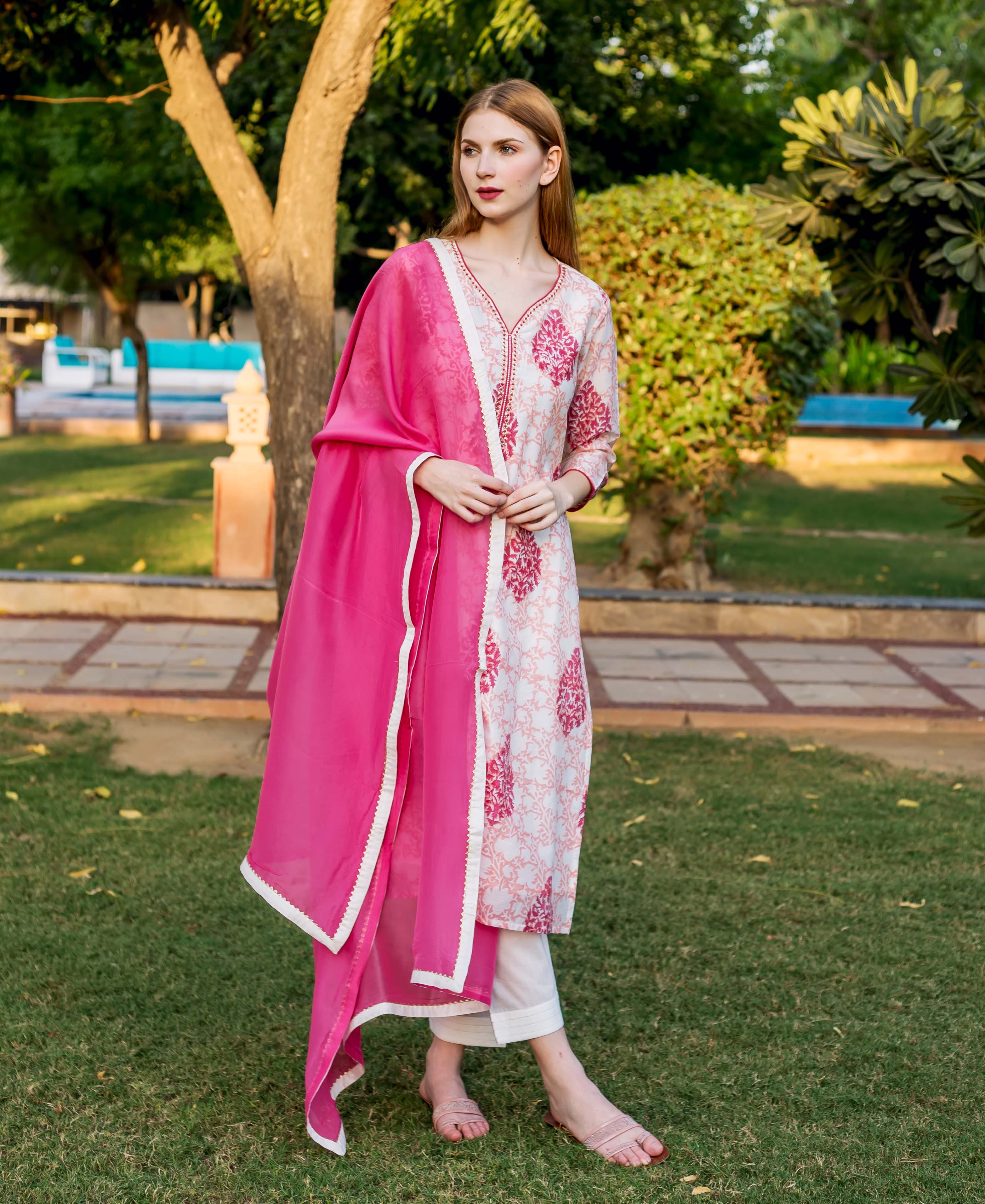 Vibrant pink solid organza dupatta draped over a model wearing a white printed kurta set.