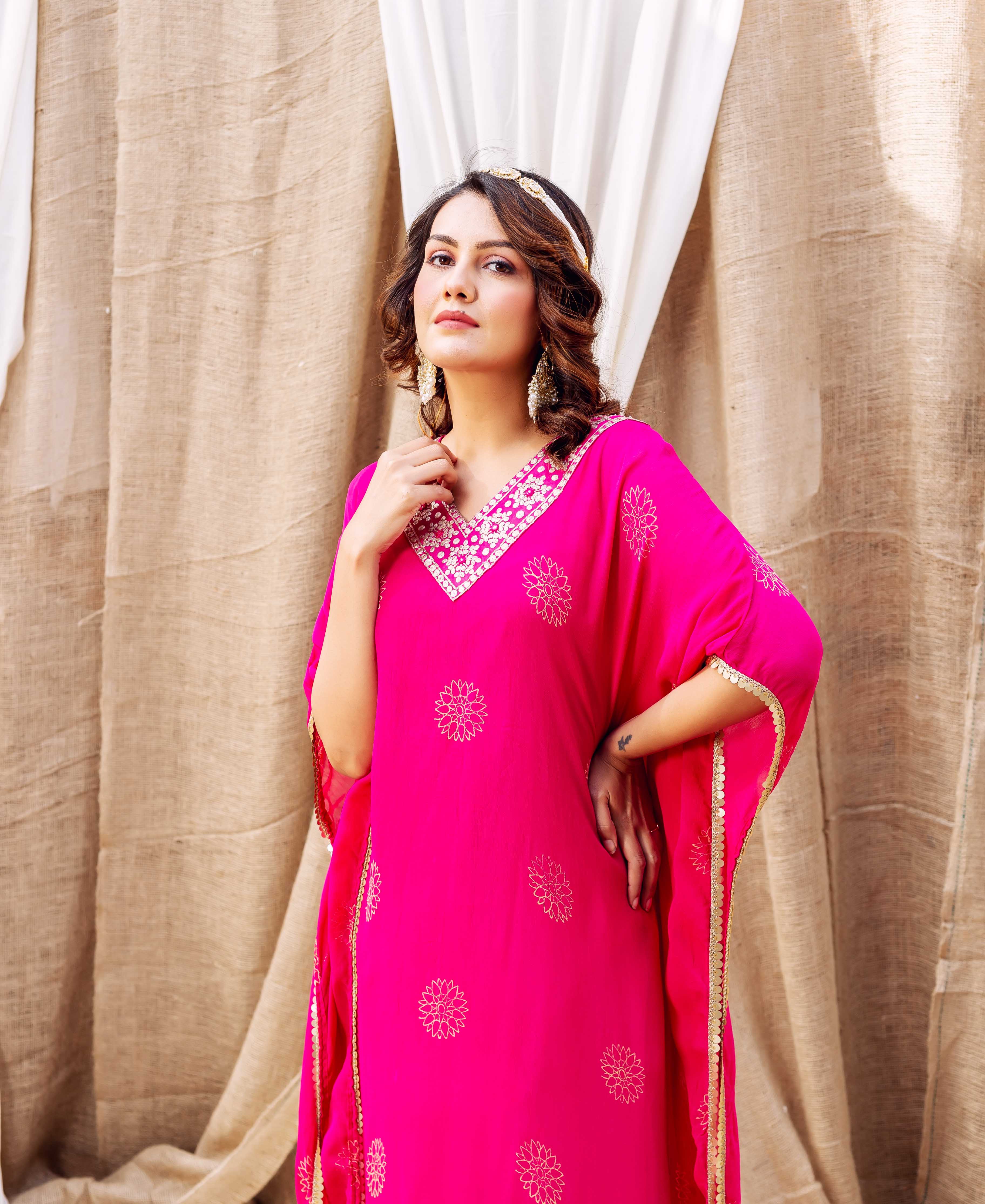 Half-body model wears a magenta embroidered kaftan with gold floral block print.