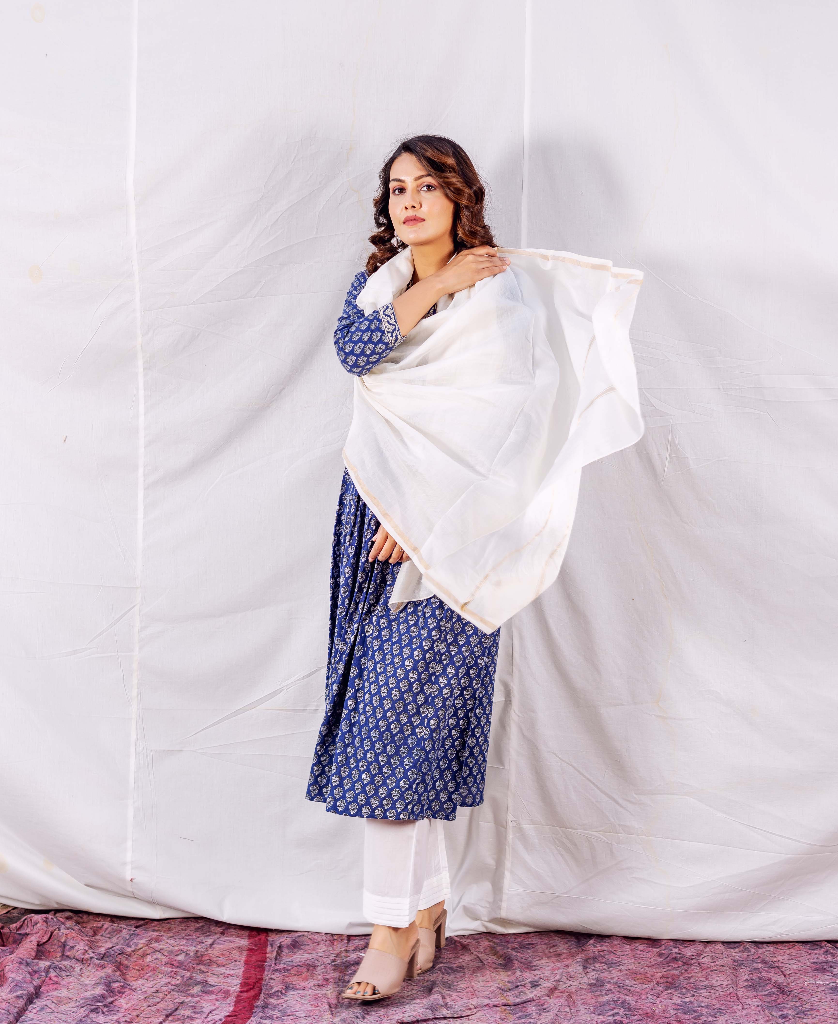 Model in a blue hand-block-printed kurta, white pants, and plain white Kota Doriya dupatta.