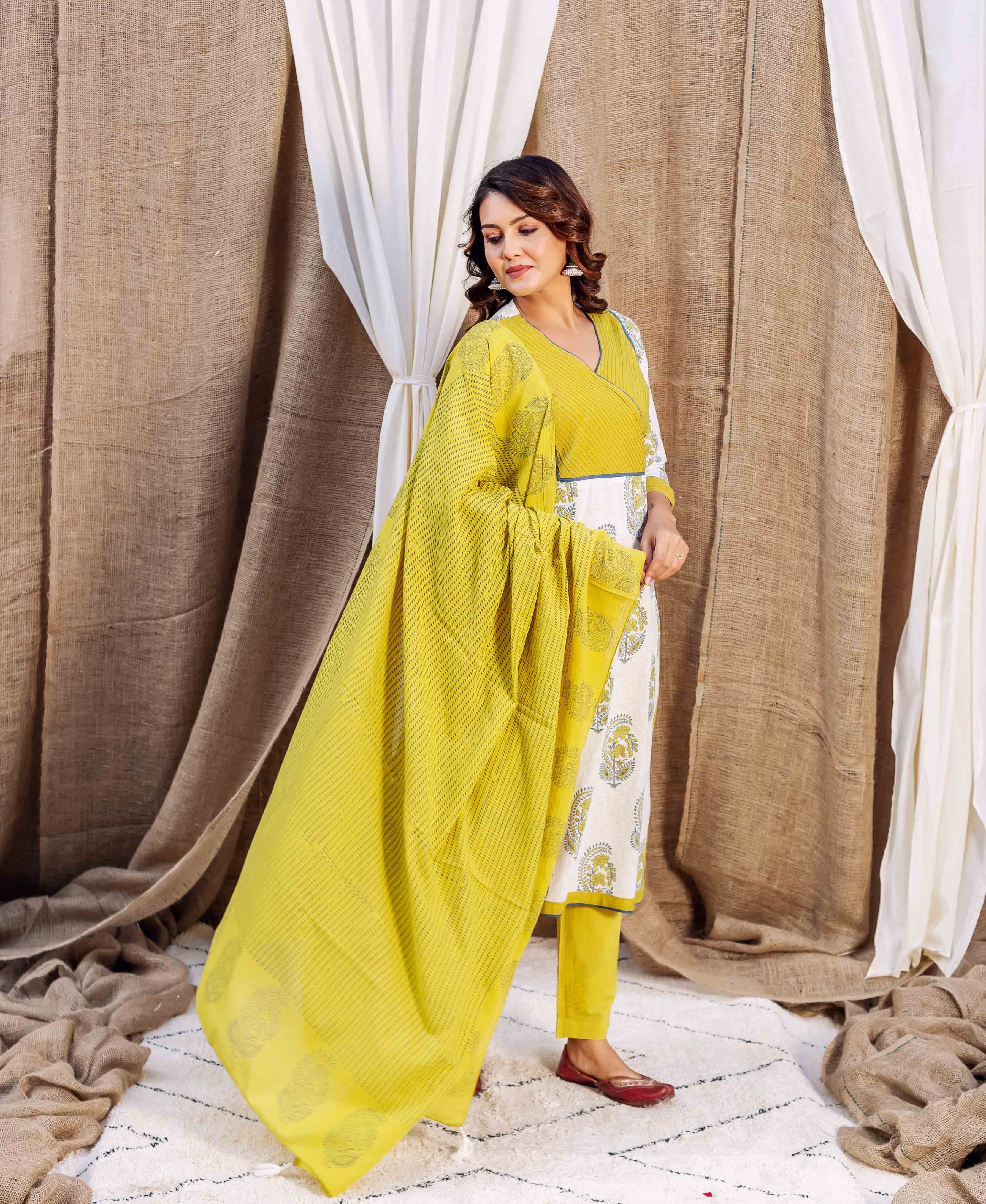 Model in full-length wearing an ochre hand-block printed cotton dupatta over a white suit.