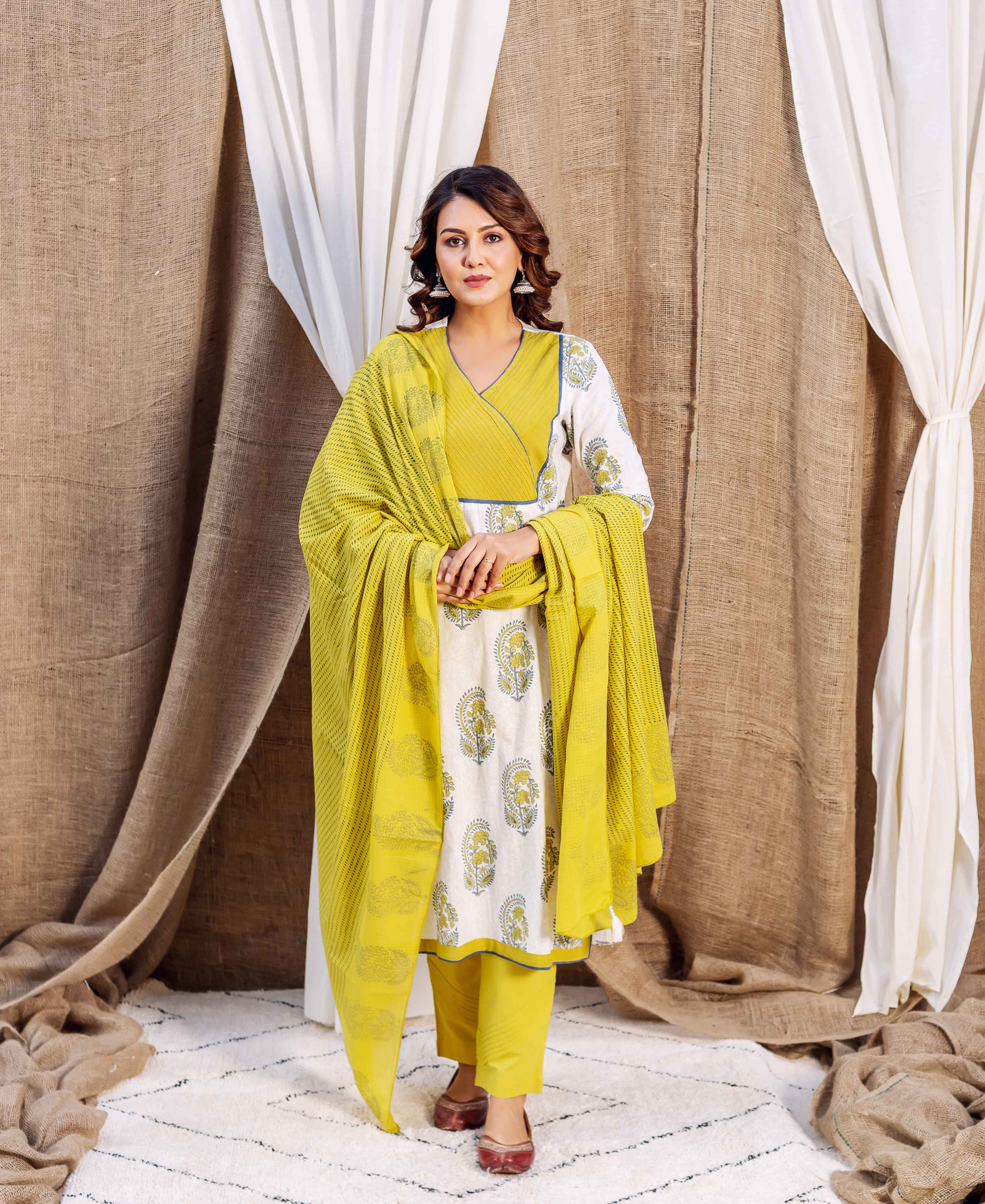 Full shot of model in ochre and white block-printed ethnic kurta set with a matching dupatta.