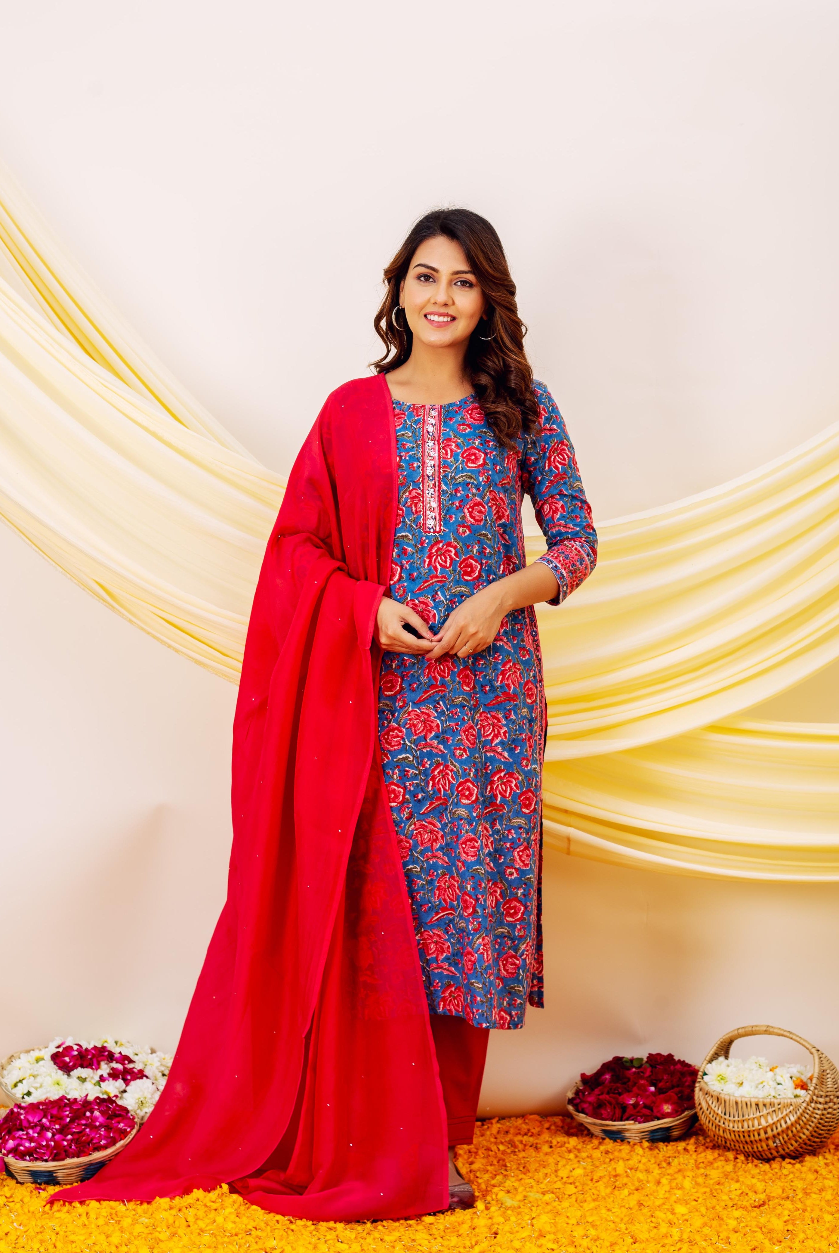 Front view of model wearing blue floral embroidered kurta with red dupatta and bottoms.