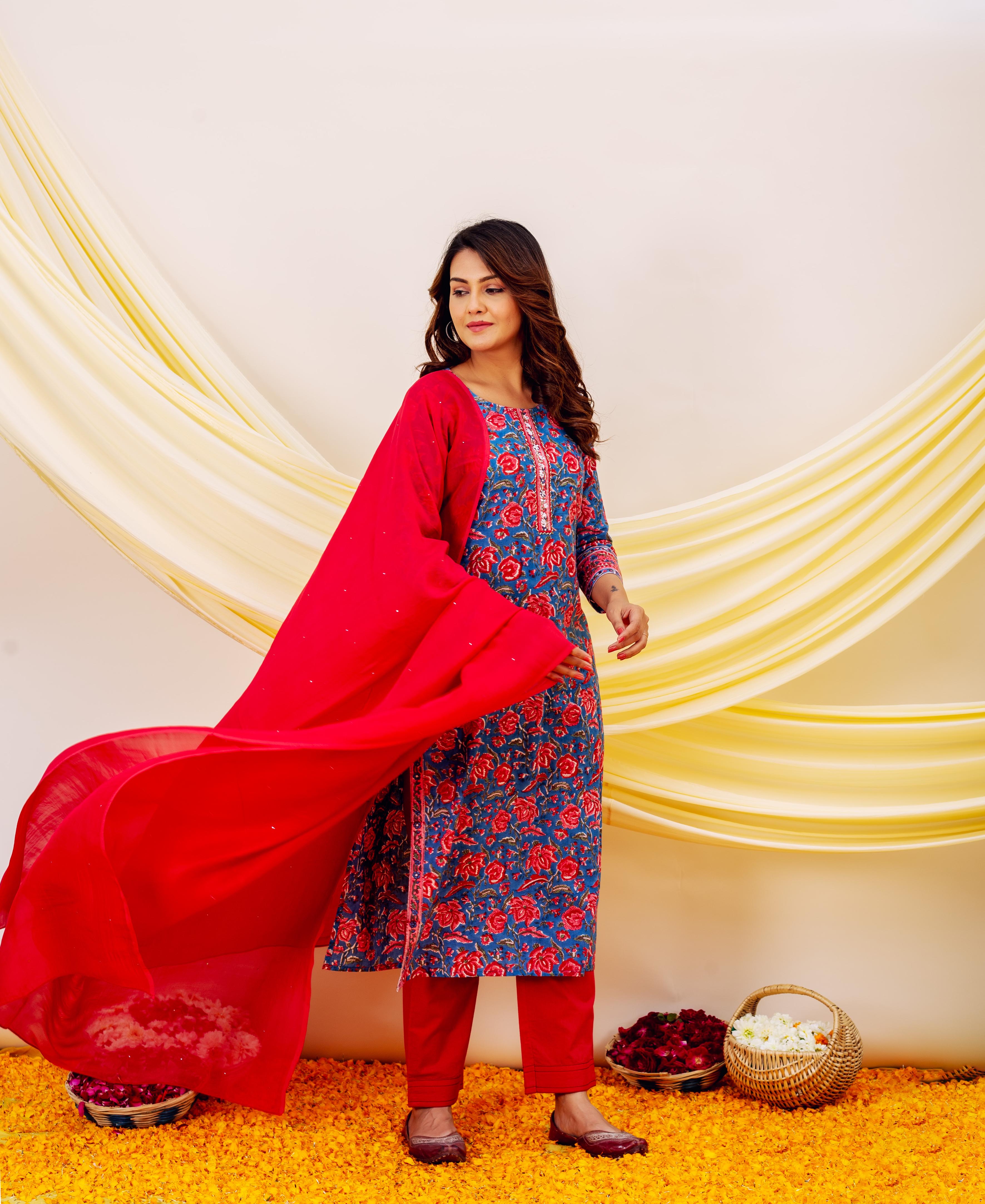 Model wears blue floral hand-block-printed kurta with red embroidered dupatta and straight pants.