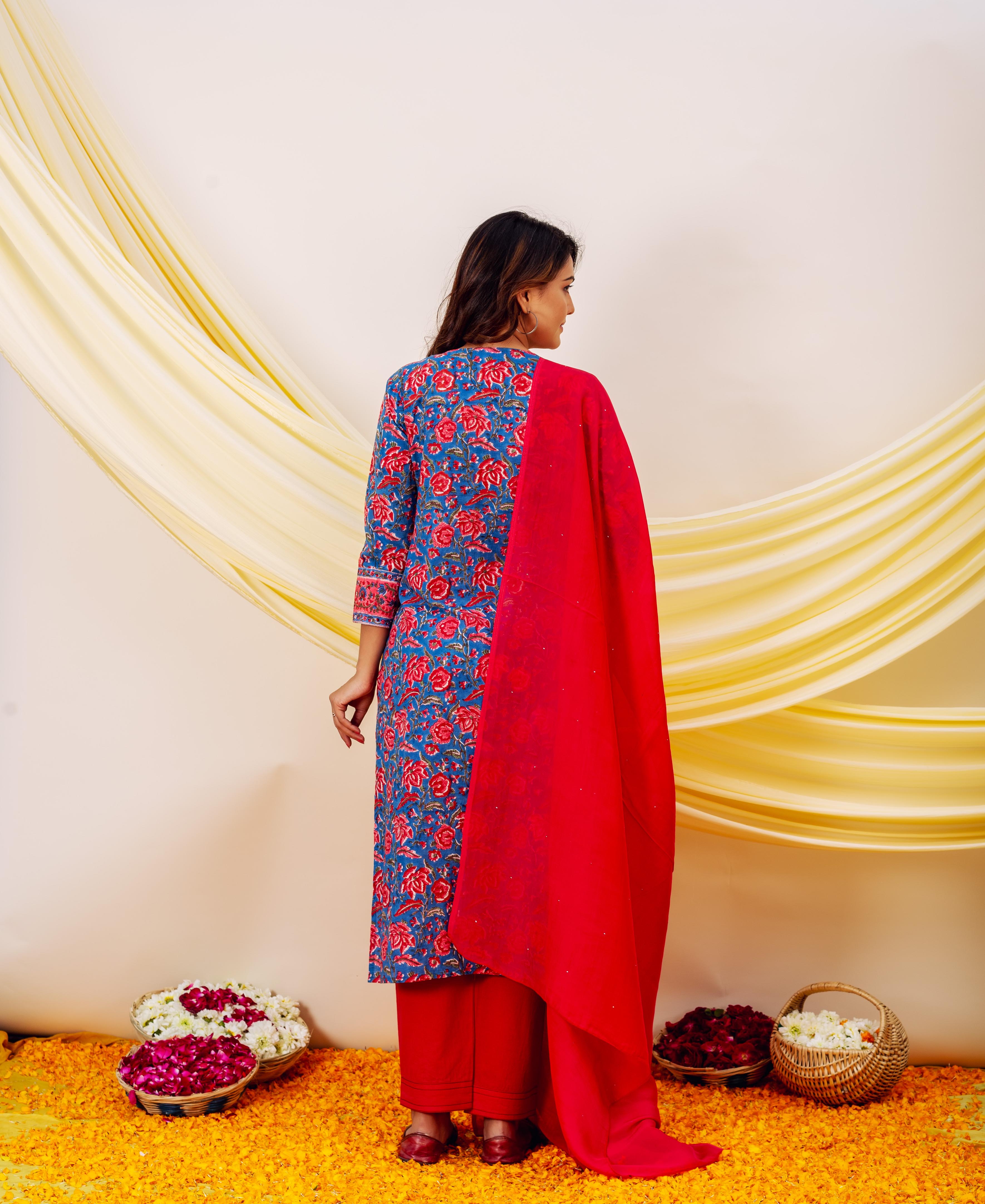 Back view: Model in blue floral hand-block printed kurta, red pants, and matching dupatta.