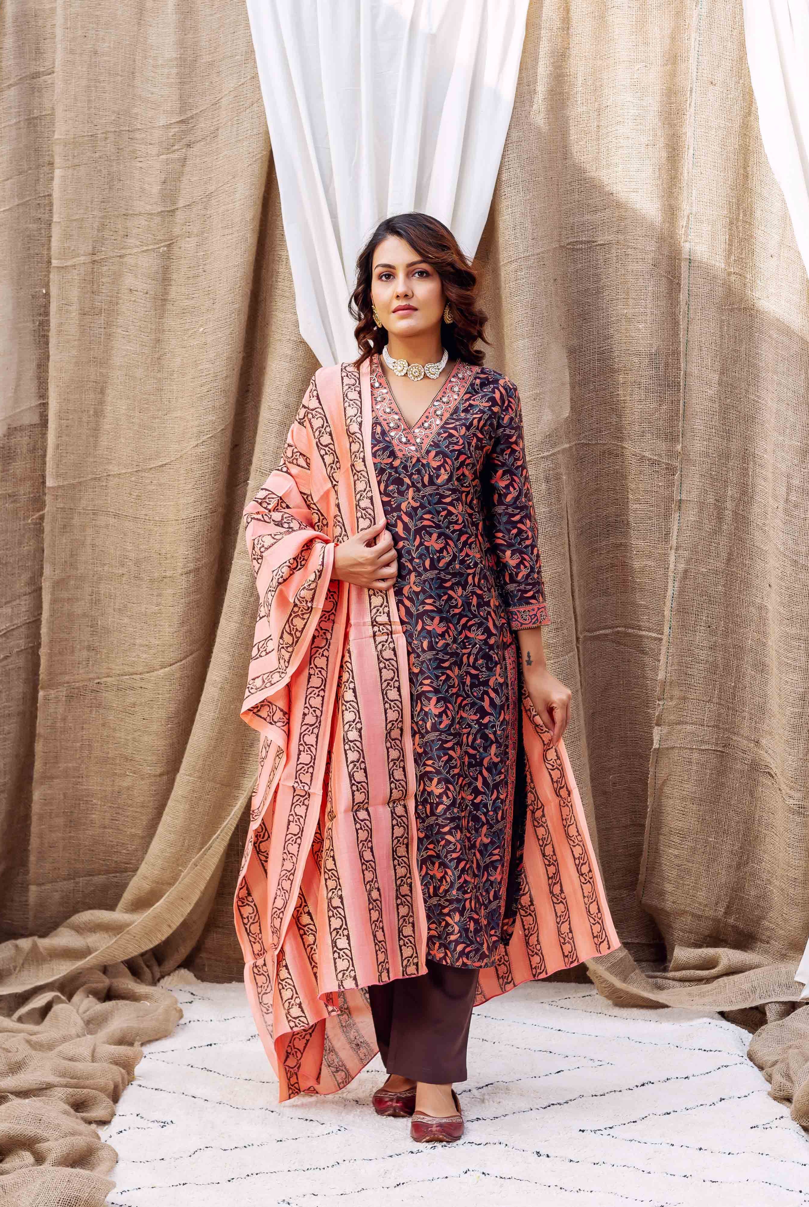 Woman wearing dark blue and peach hand-block-printed silk kurta with floral patterns and accessories.