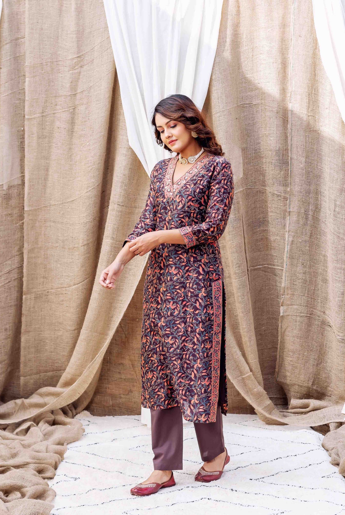 Front view: model in dark hand-block printed floral kurta, solid bottoms, and ethnic shoes.