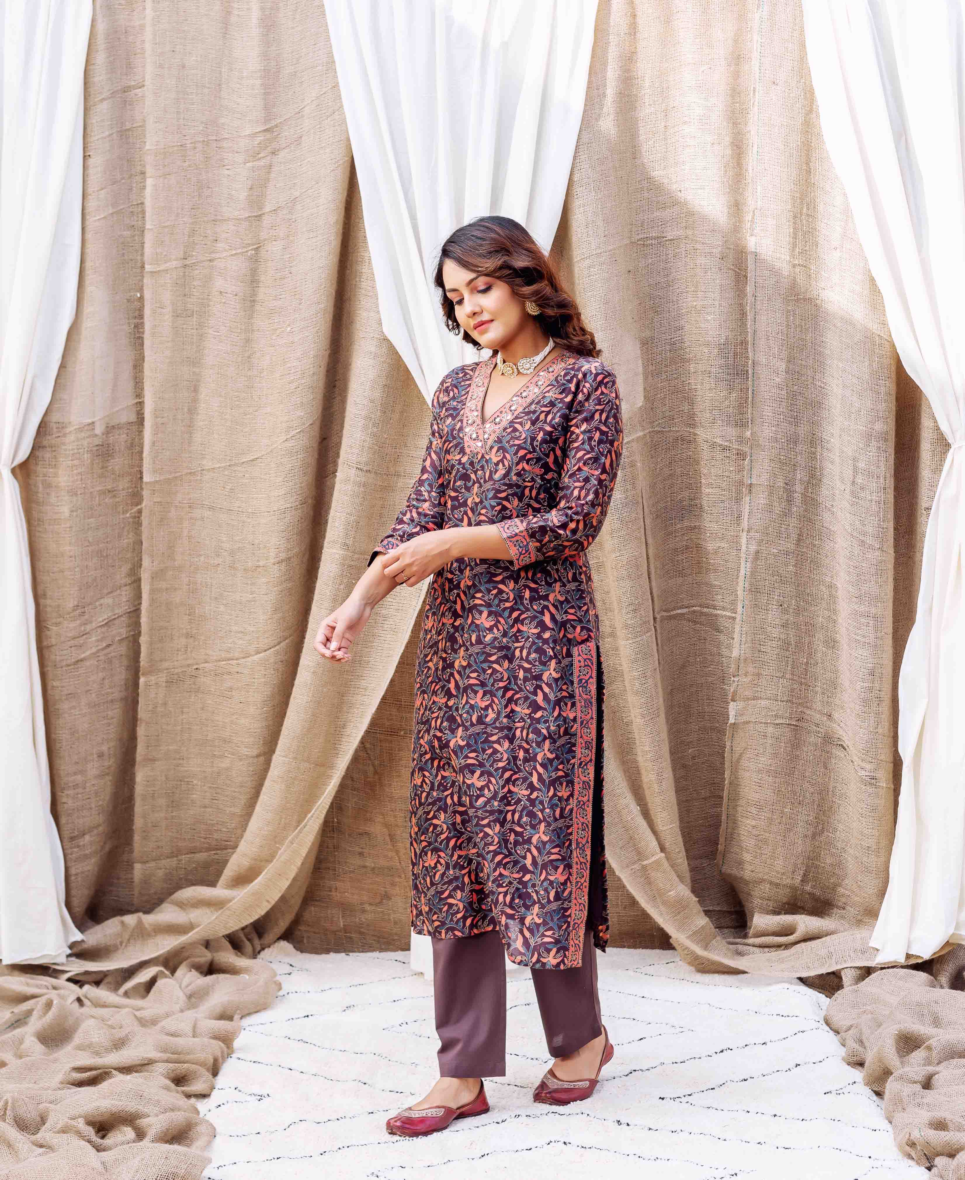 Front view: model in dark hand-block printed floral kurta, solid bottoms, and ethnic shoes.