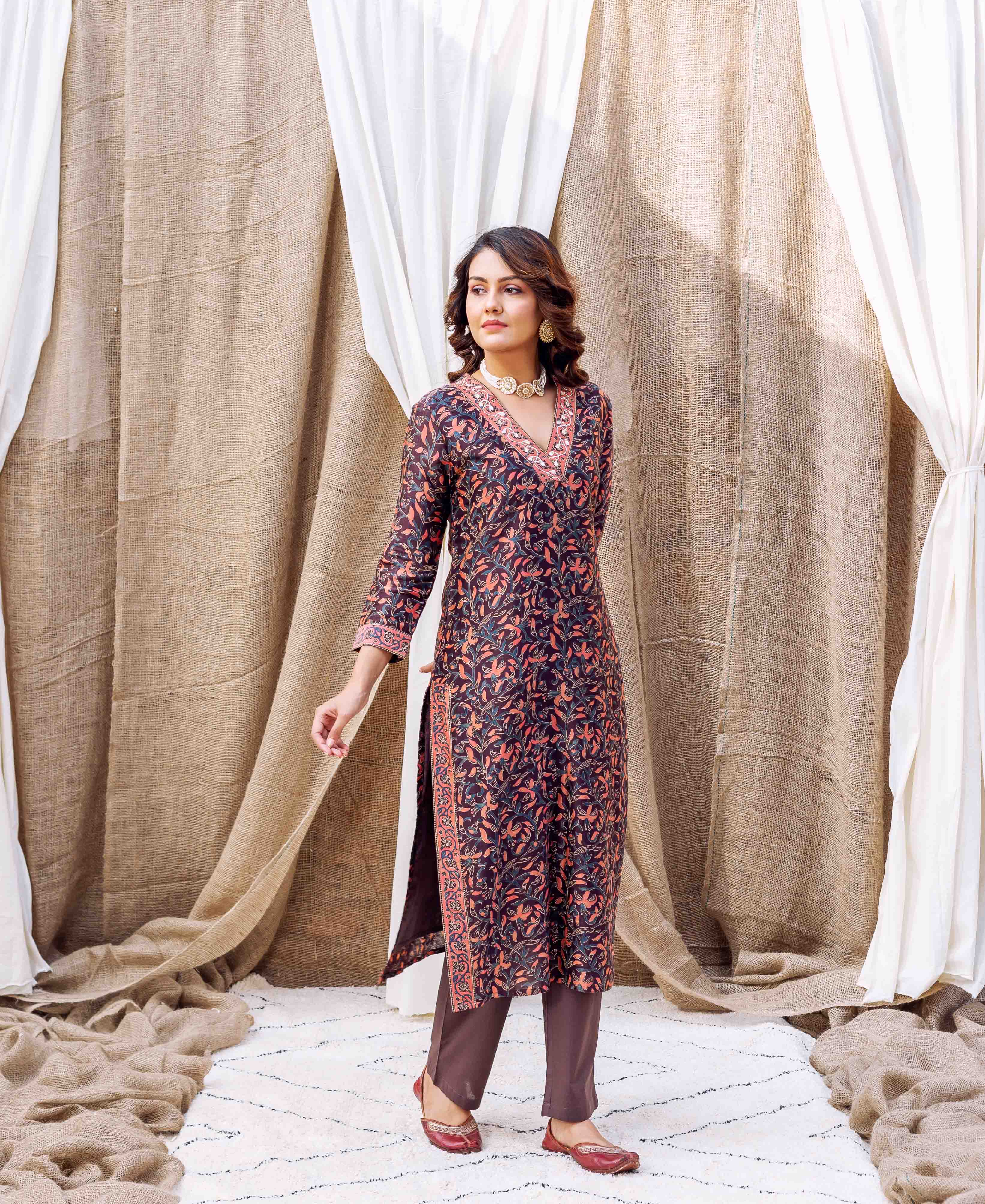 Model in front view wearing a dark hand-block printed kurta with orange and blue floral print.