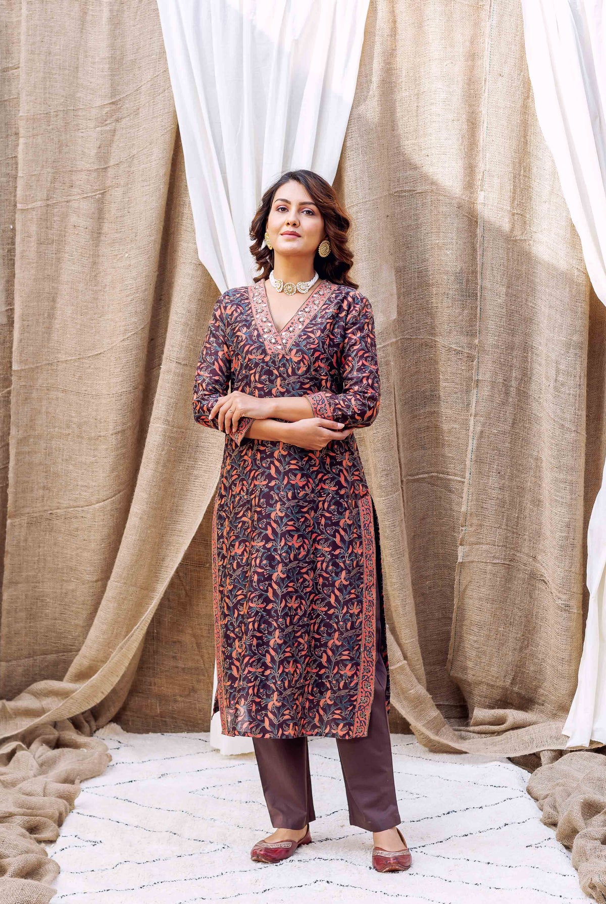 Woman wearing dark purple and orange floral hand-block-printed silk chanderi kurta with brown pants.