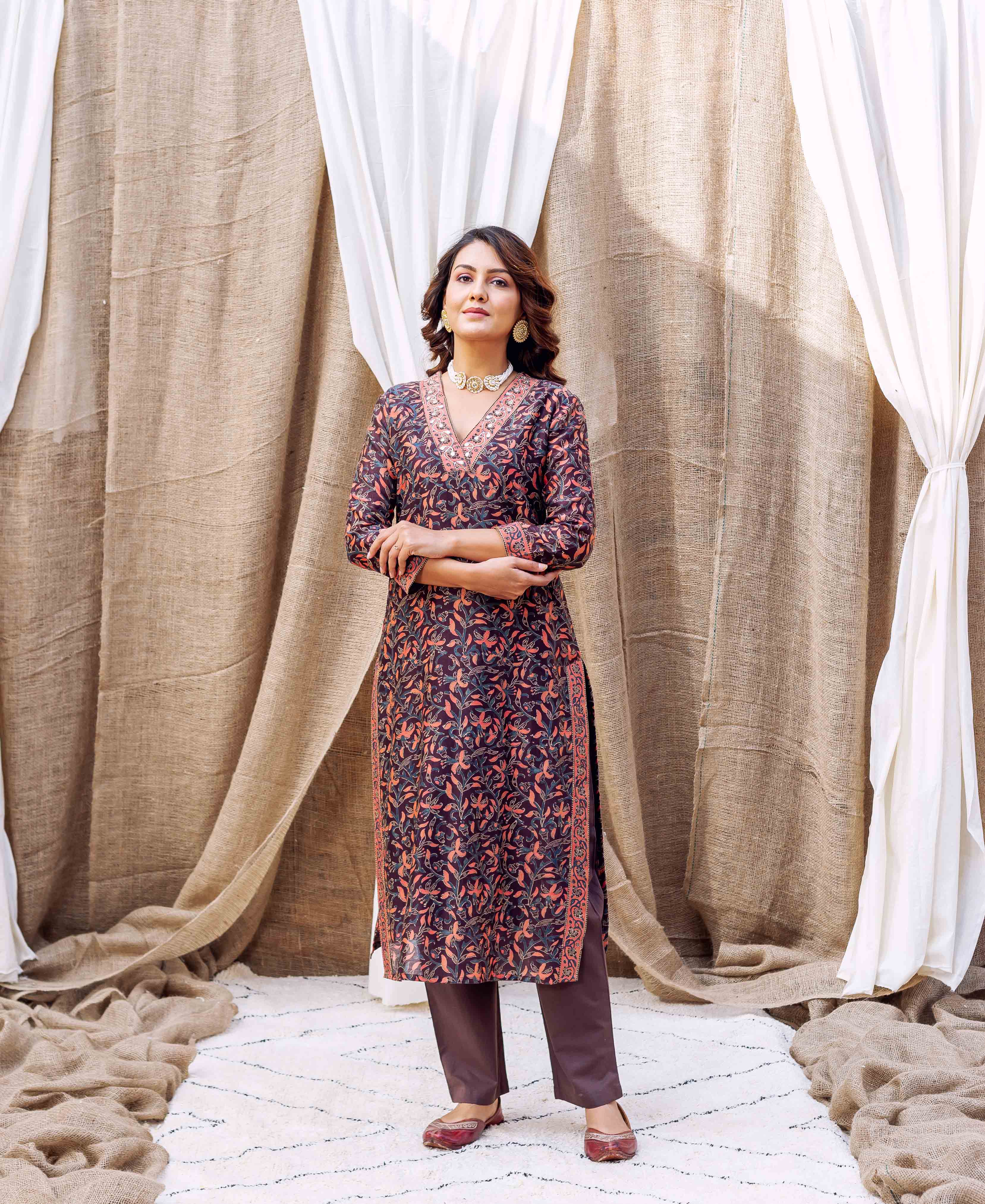 Woman wearing dark purple and orange floral hand-block-printed silk chanderi kurta with brown pants.