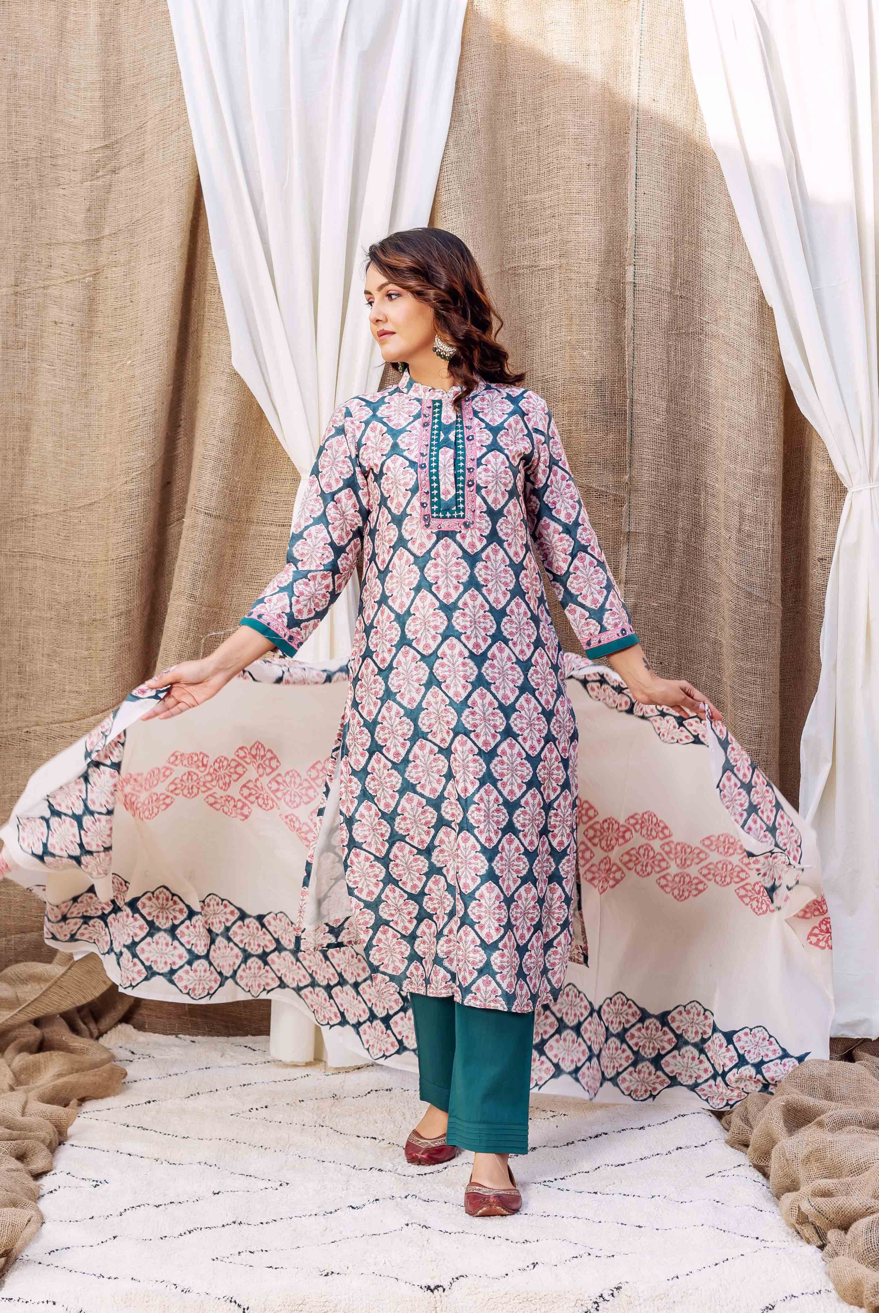 A woman models a teal green block-printed kurta with pink floral patterns.