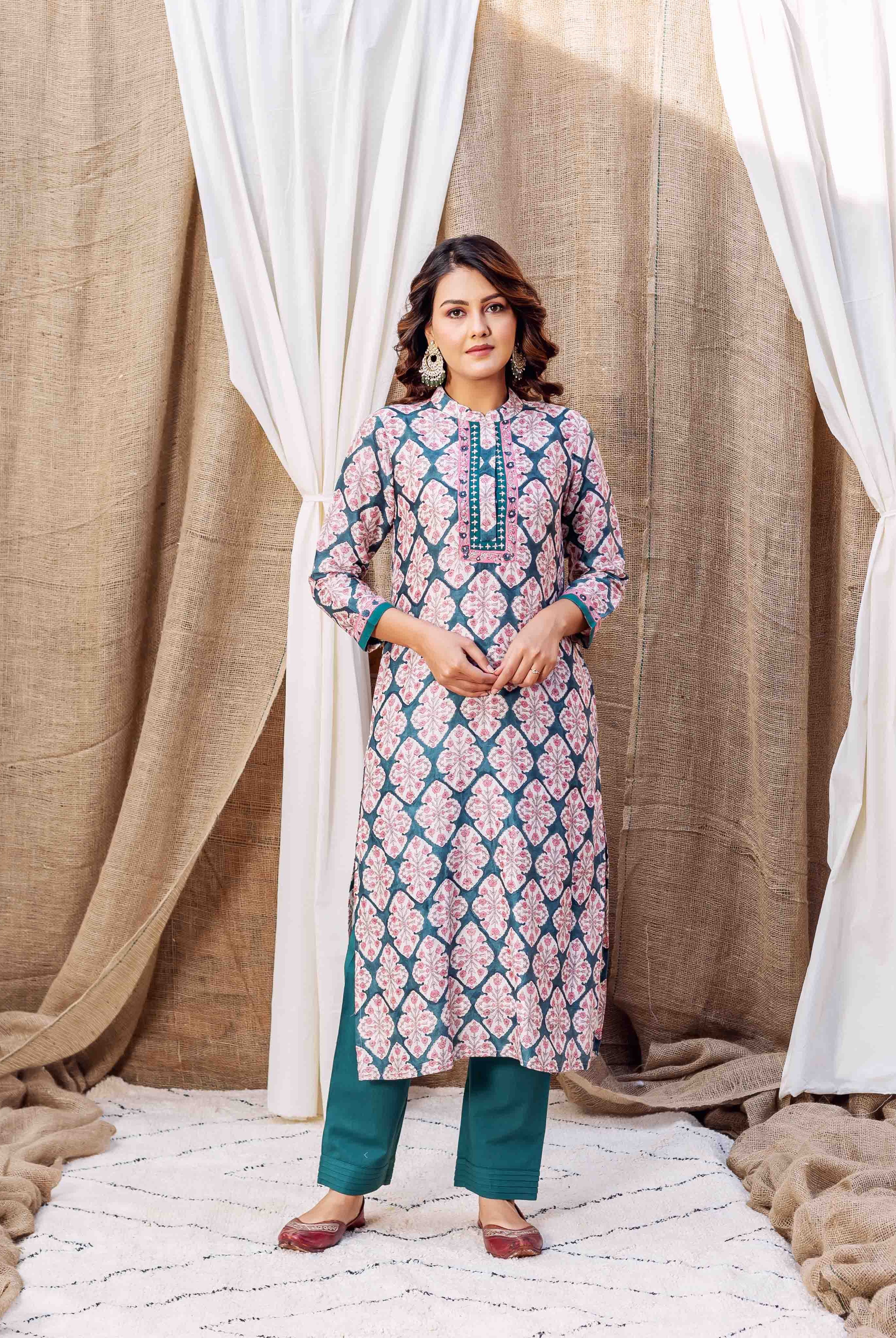 A model wearing a teal green block-printed kurta with pink floral patterns.