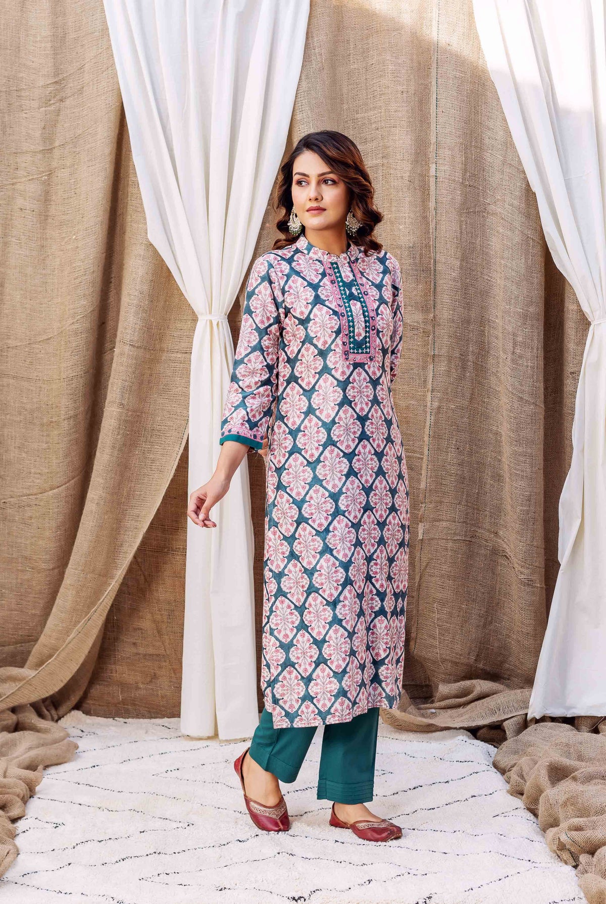 Full shot of a woman in a teal green and pink geometric block-printed chanderi kurta with matching pants.