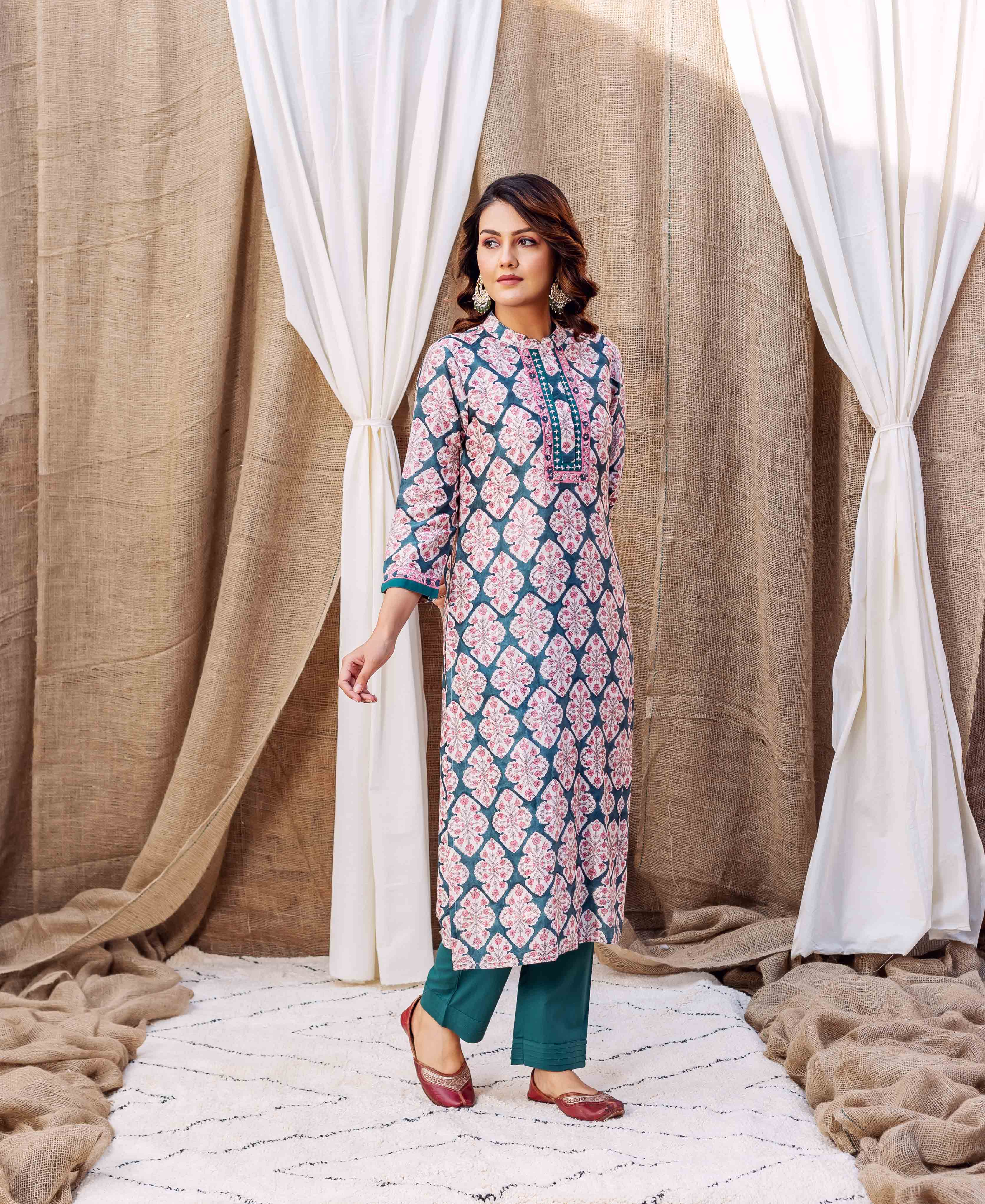 Full shot of a woman in a teal green and pink geometric block-printed chanderi kurta with matching pants.
