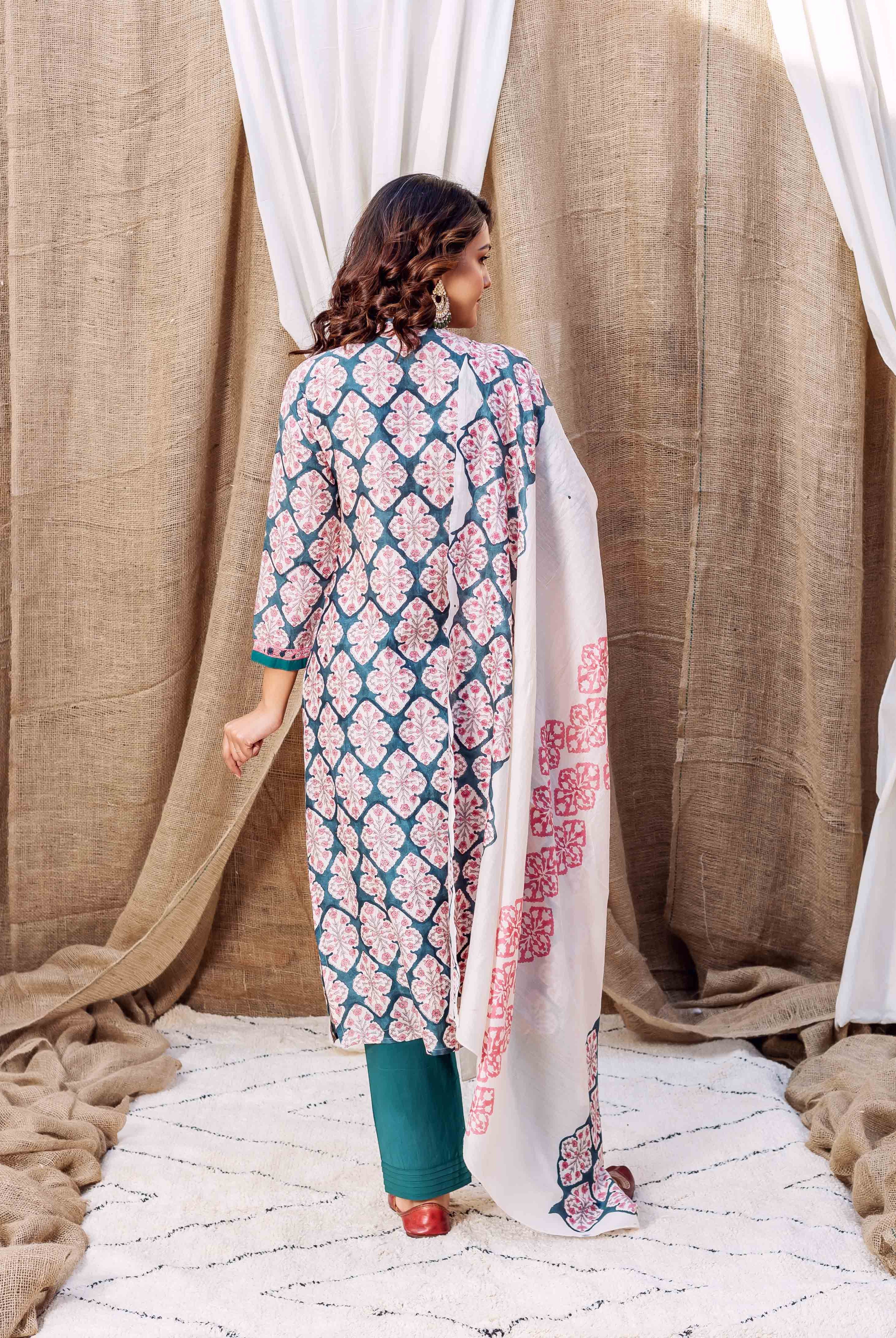 Back view of model in teal green block printed kurta, pink motifs, and white dupatta.