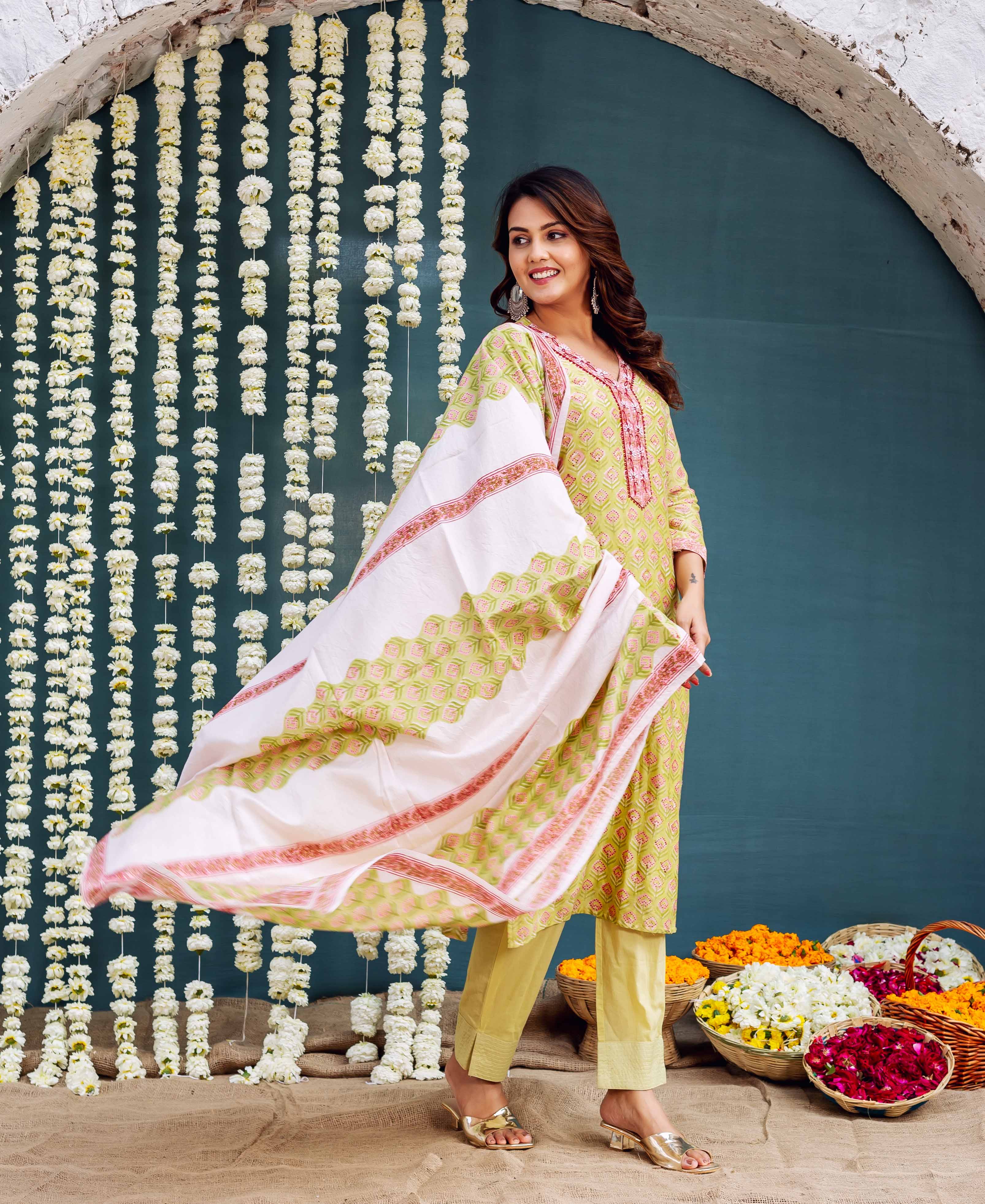 Model wears a green block-printed kurta set with a flowing white and green printed dupatta.