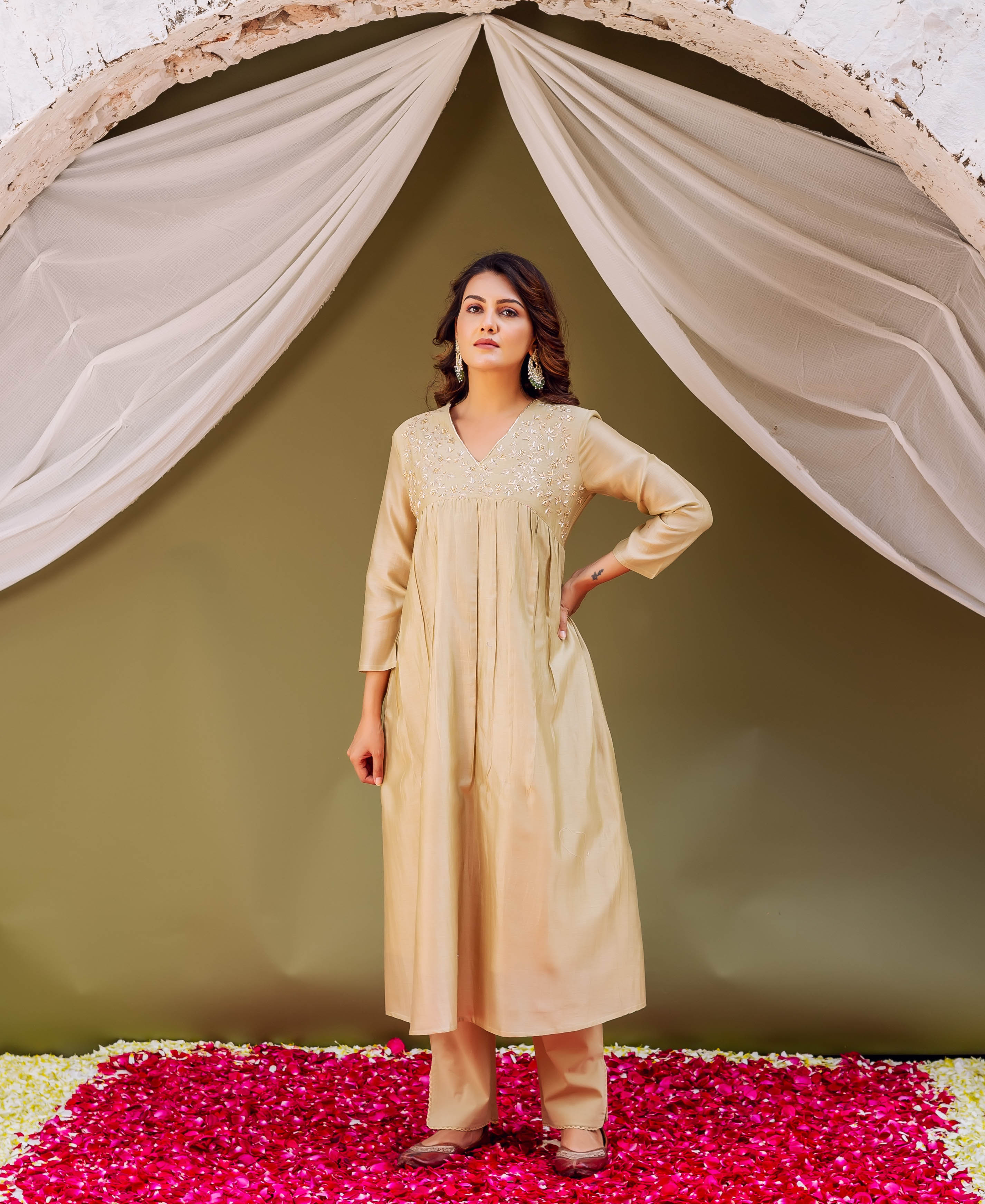 Model wears a light gold silk chanderi kurta with delicate embroidered V-neck and pleats.