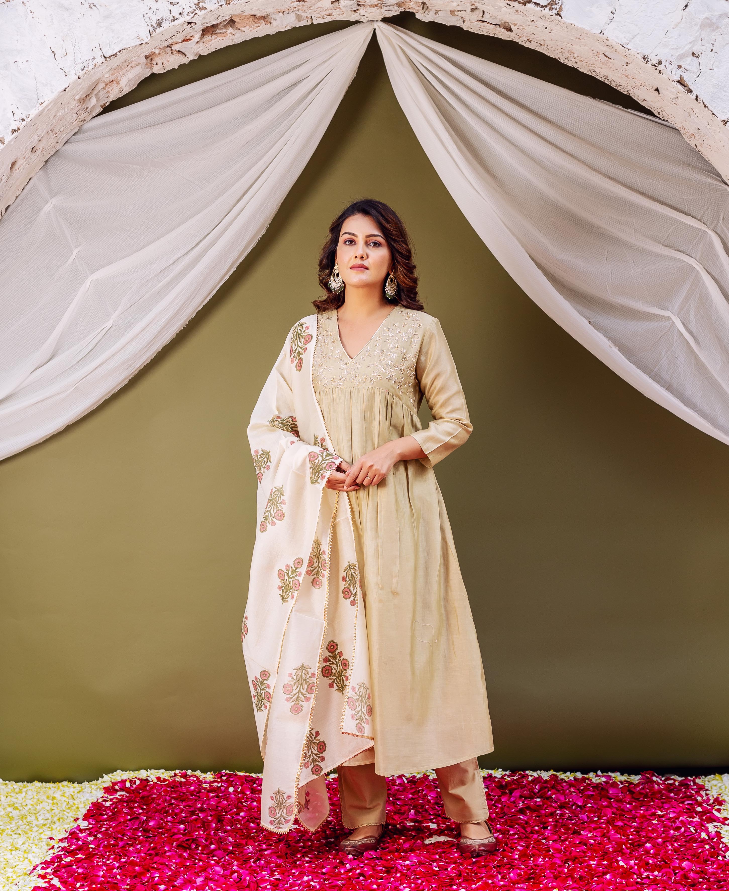 Woman models a light olive embroidered kurta set with a hand-block-printed floral dupatta.