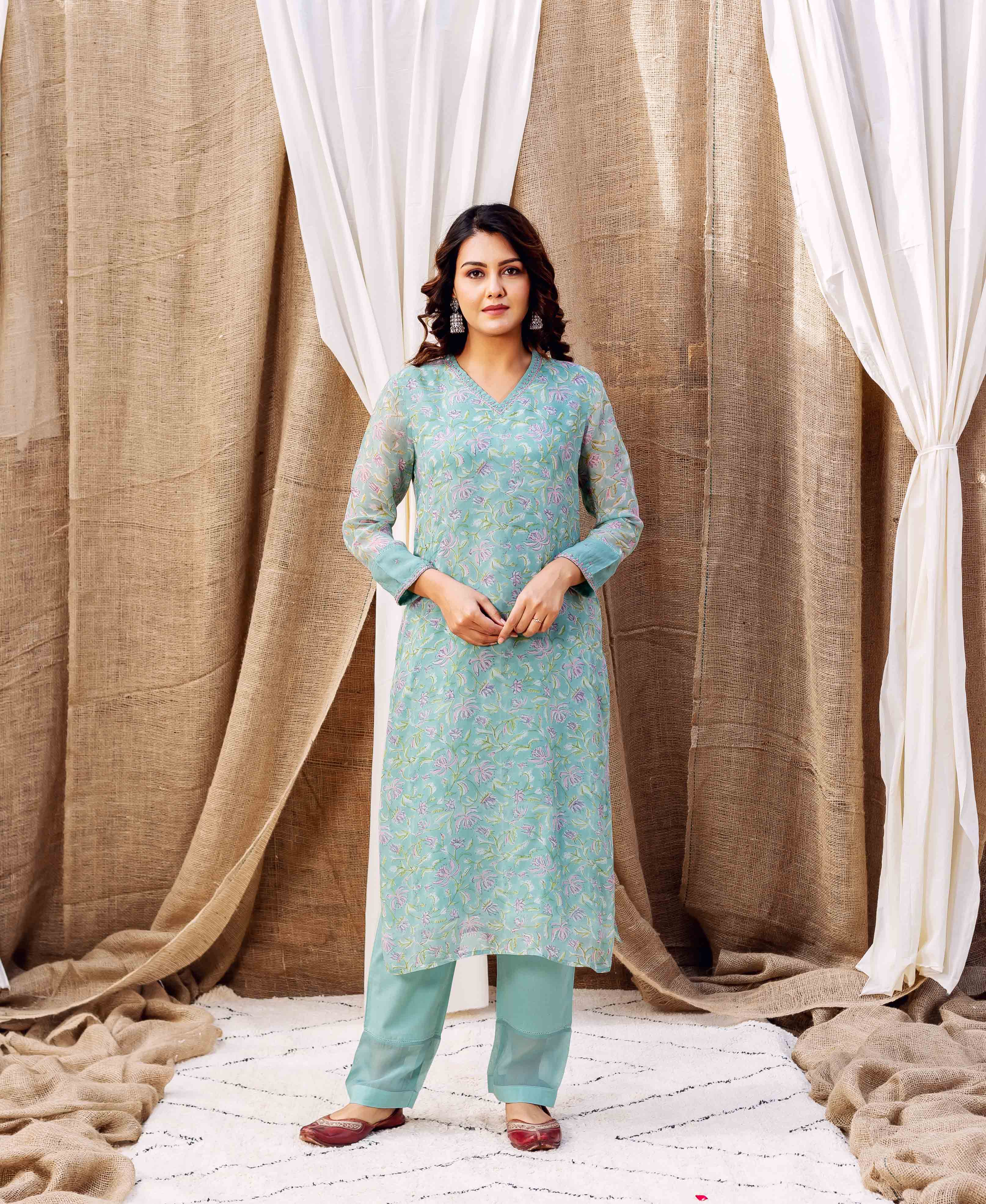 A model wearing a turquoise kurta with a floral print.