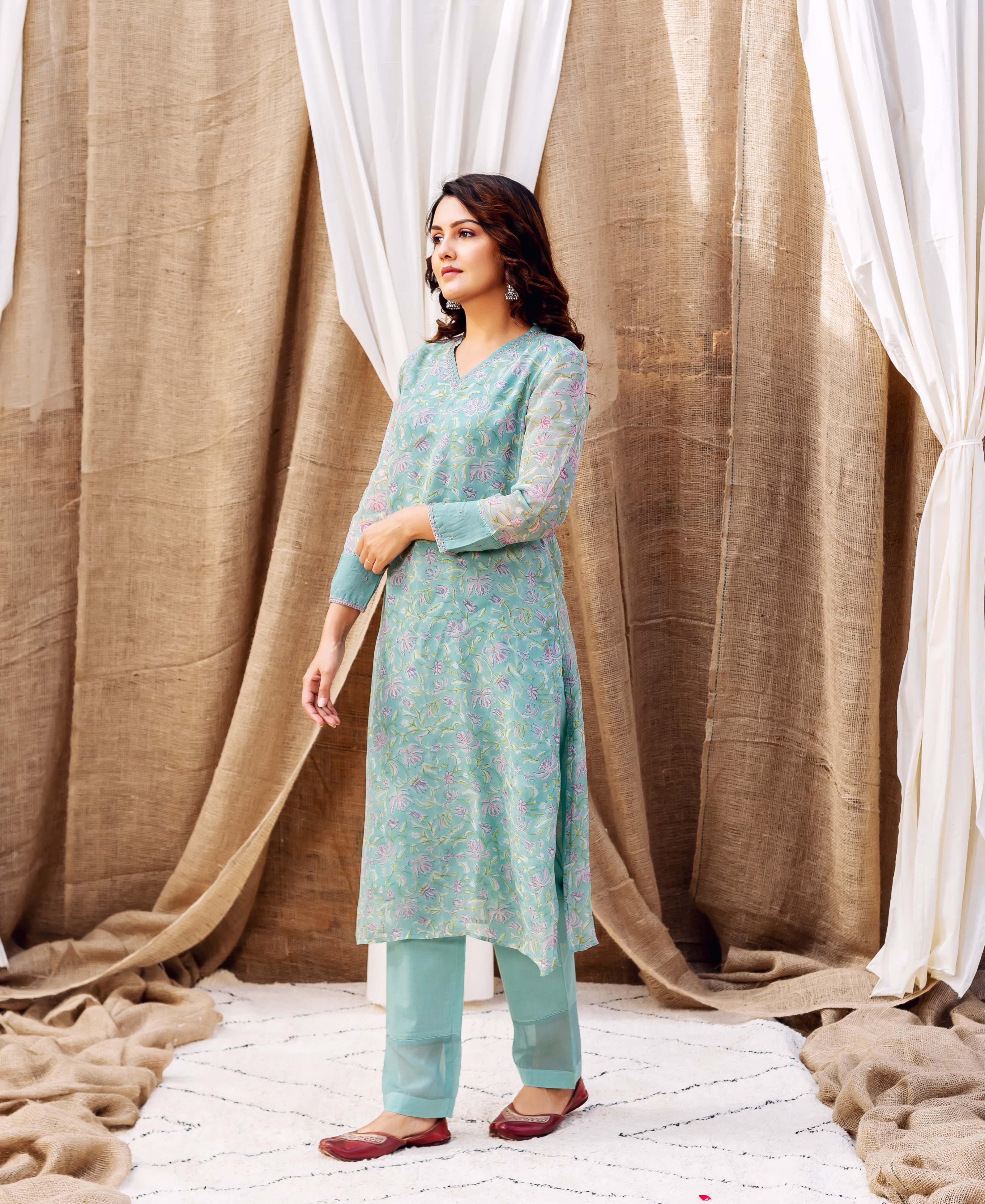 Full-length model in a turquoise ethnic kurta and pants set with lavender floral block print.
