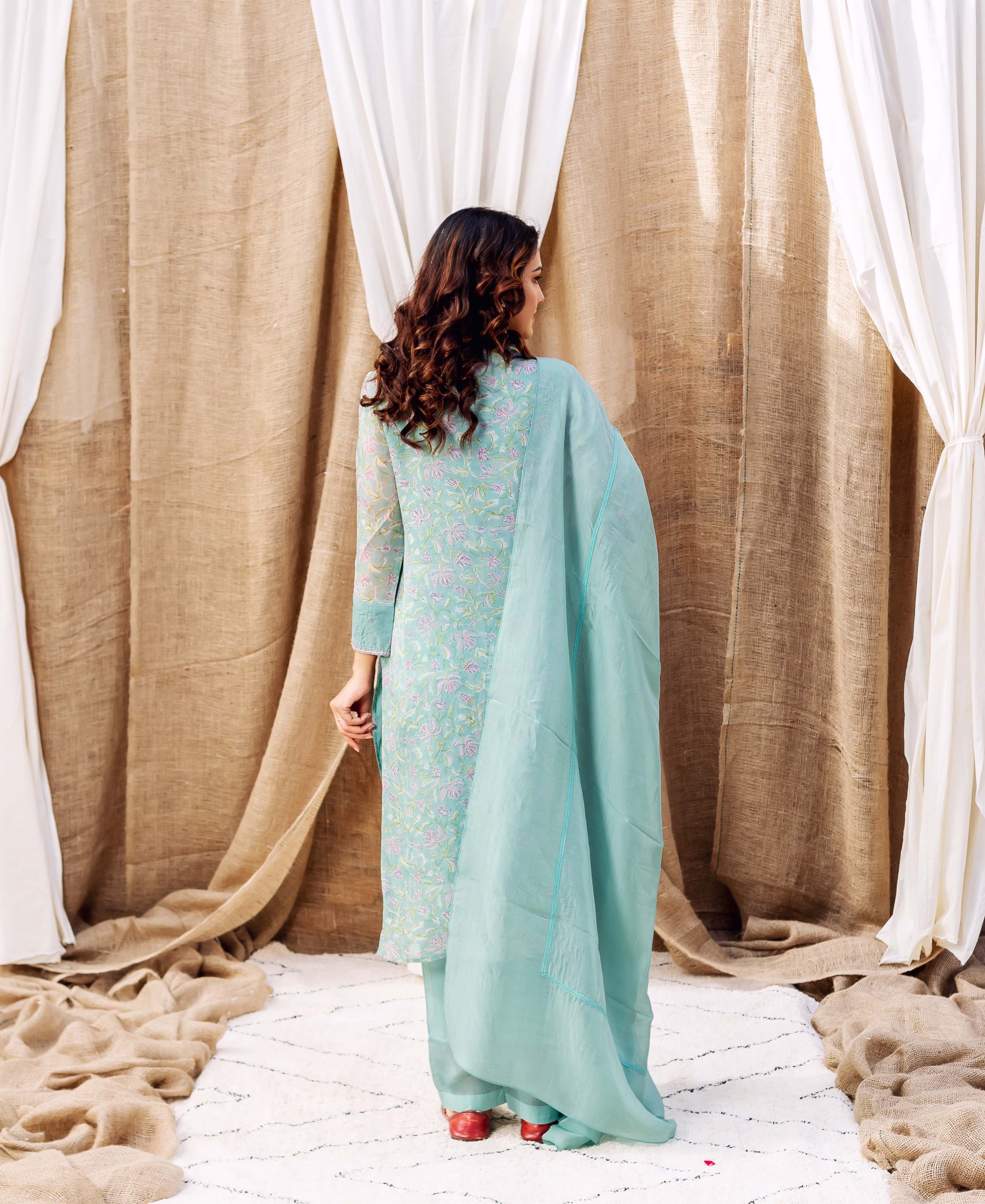 Turquoise kurta with pastel floral hand-block print and matching dupatta on a model from behind.