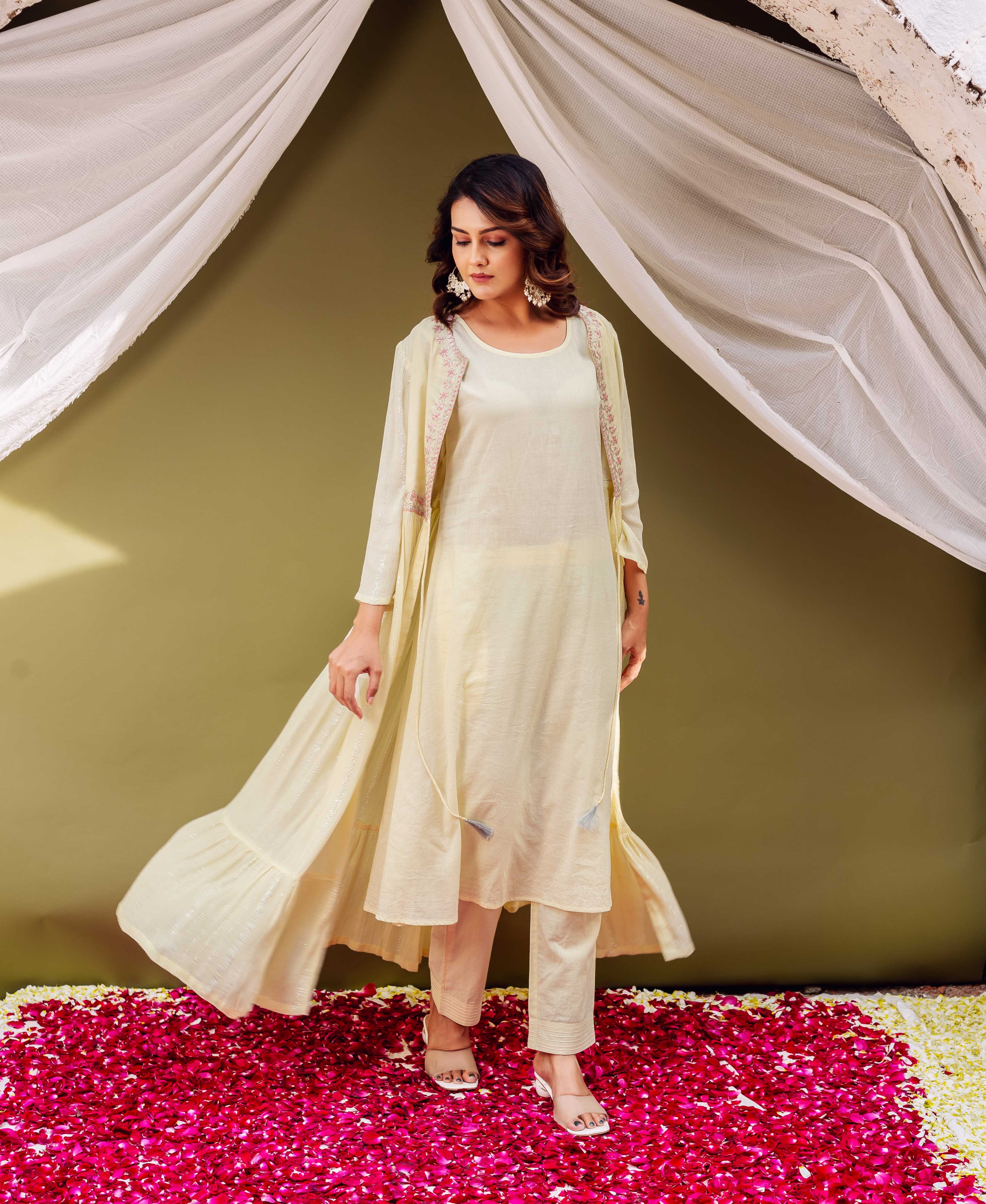 Female model wearing a shimmery cream jacket-style kurta with delicate pink printed borders.