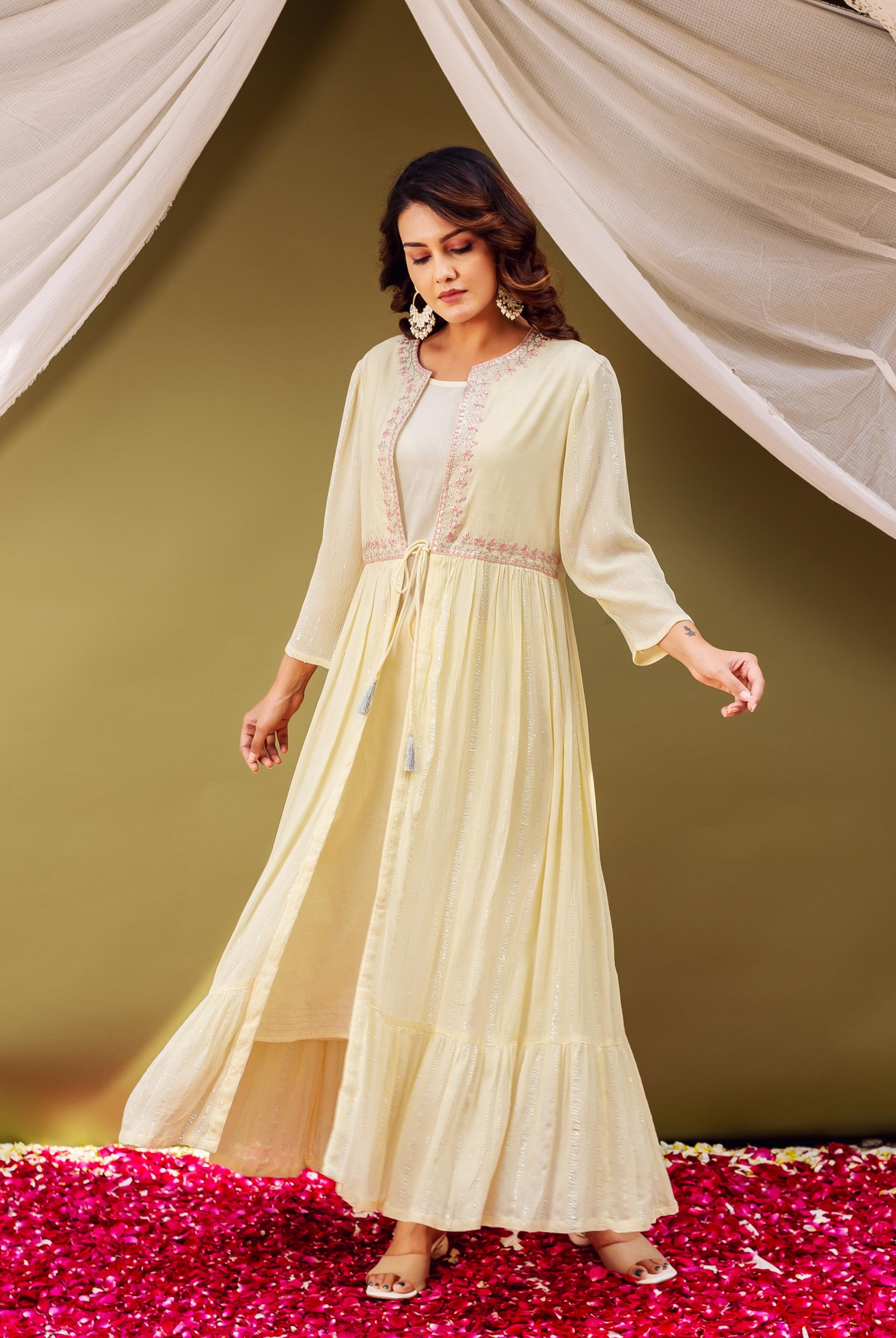 Full shot of model in a light yellow shimmer jacket kurta with delicate pink embroidery.