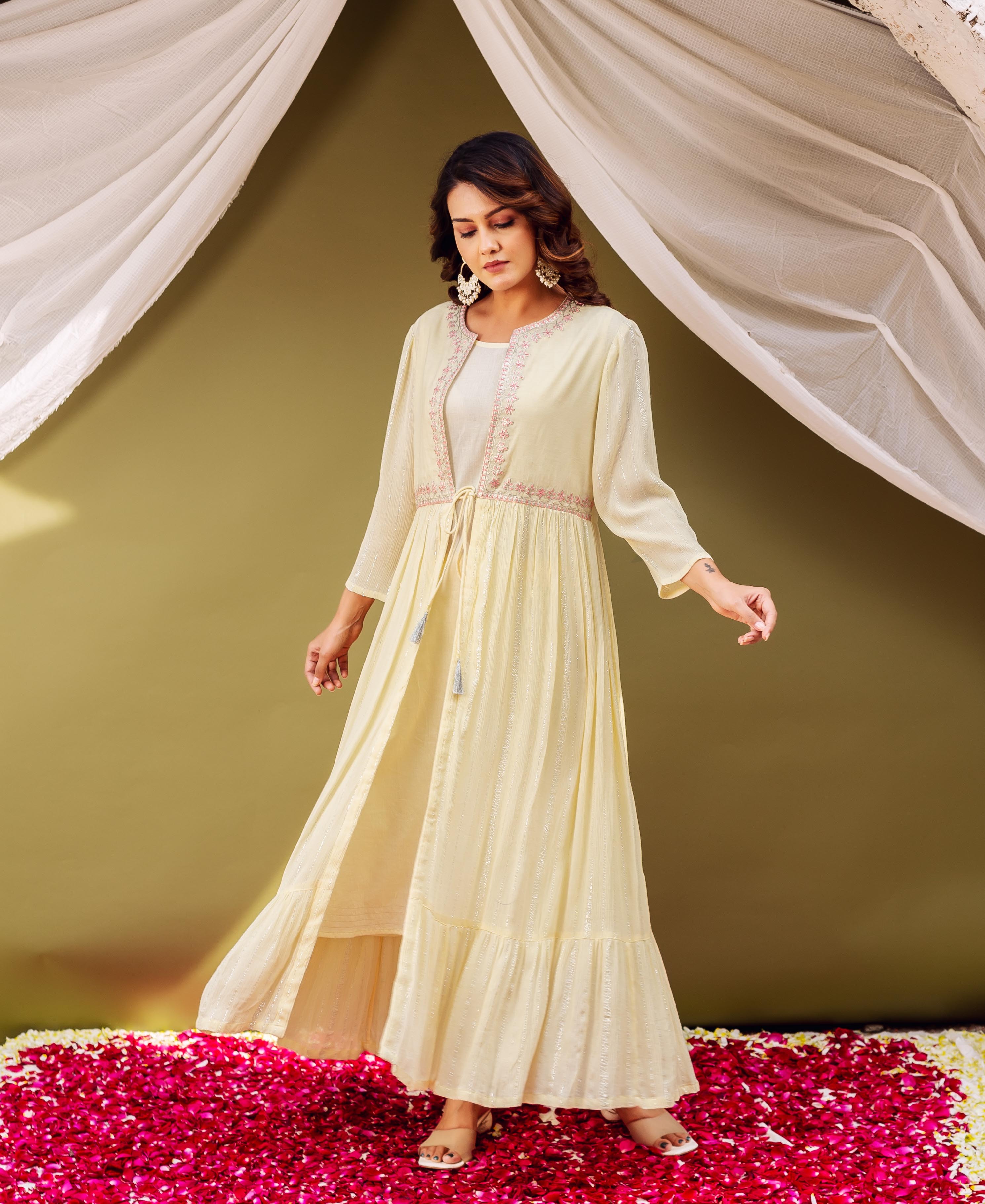 Full shot of model in a light yellow shimmer jacket kurta with delicate pink embroidery.