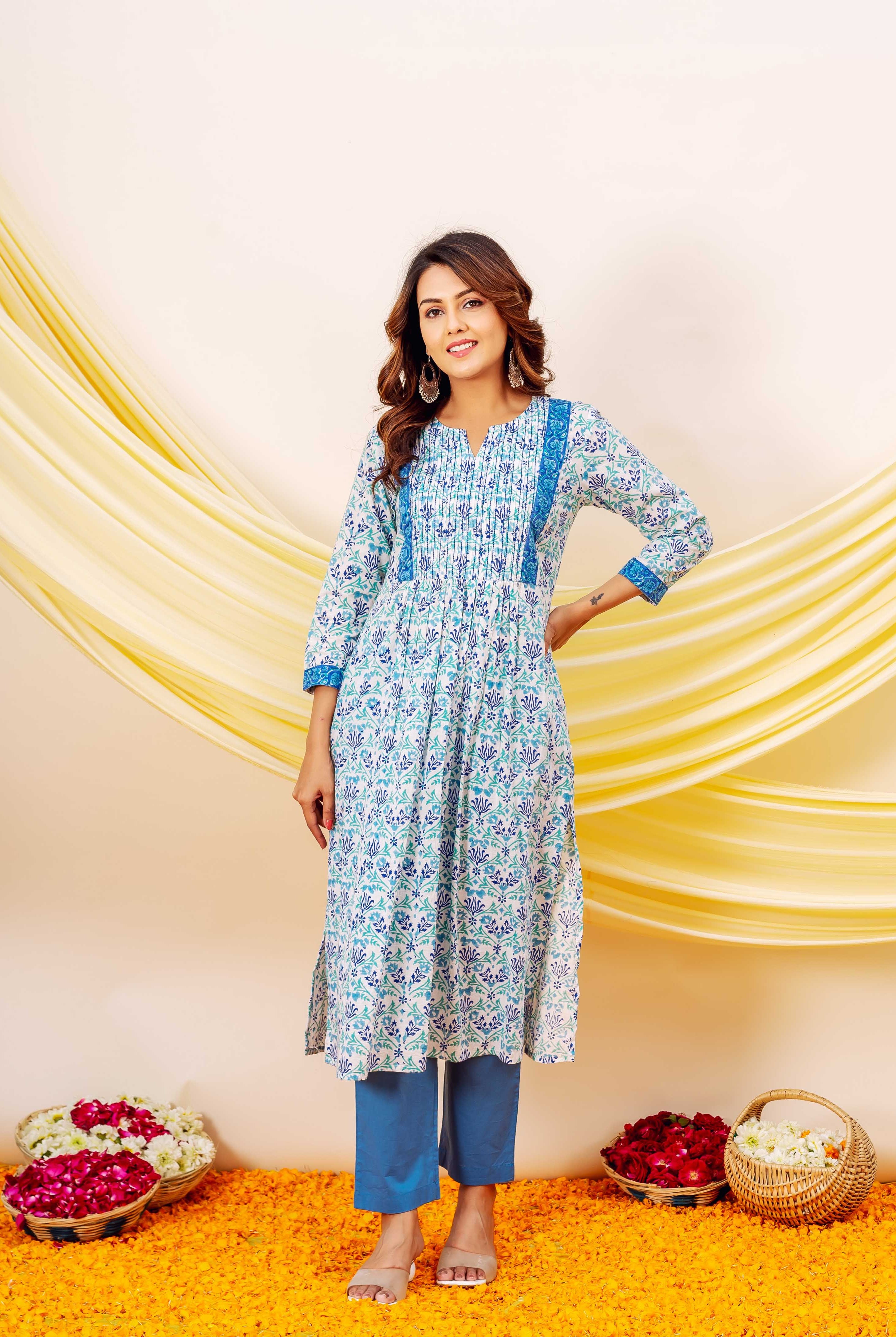 Smiling woman wearing a blue and white floral hand-block printed cotton kurta and blue pants.