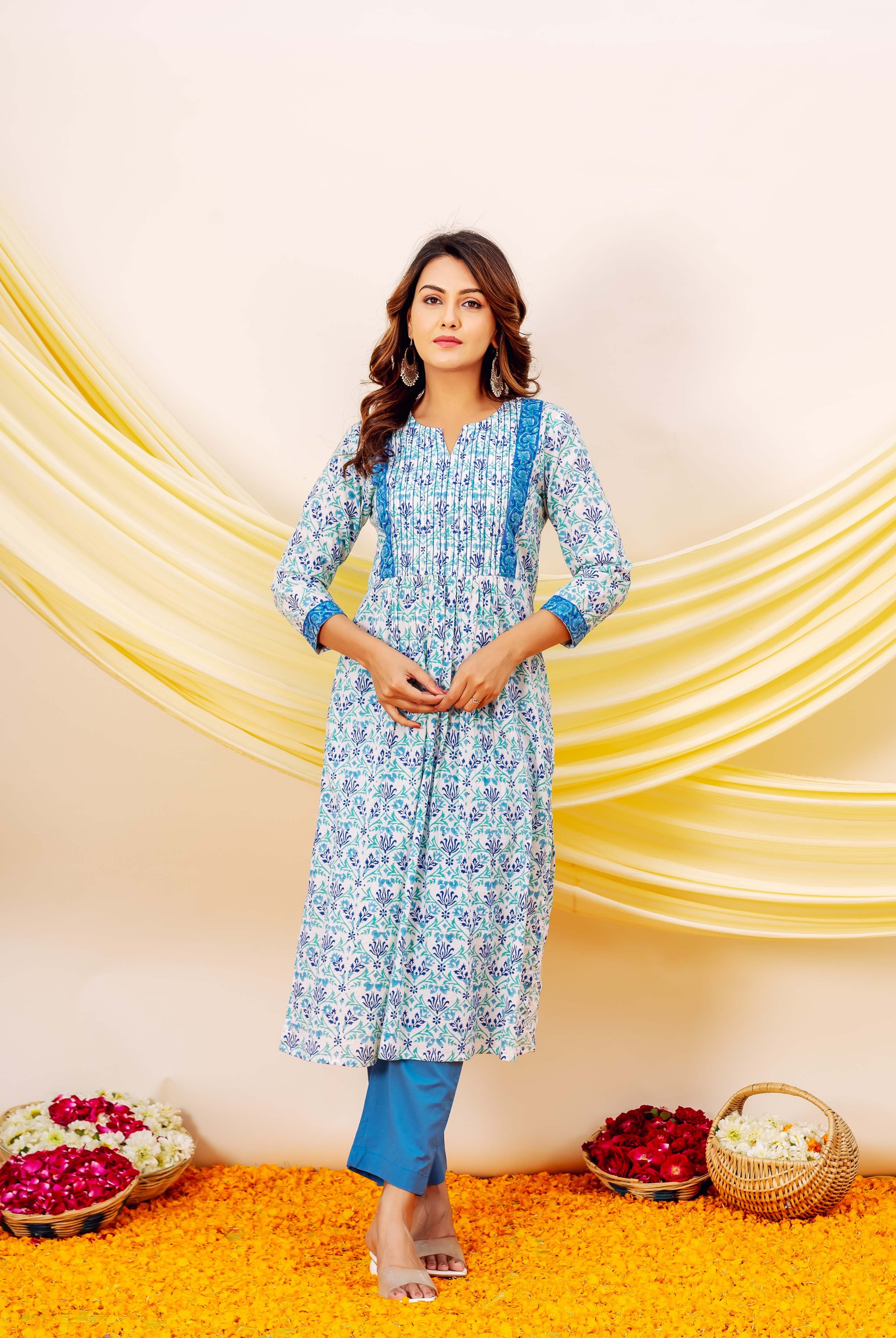 Woman standing in a white and blue floral hand-block printed cotton kurta with pleated front.