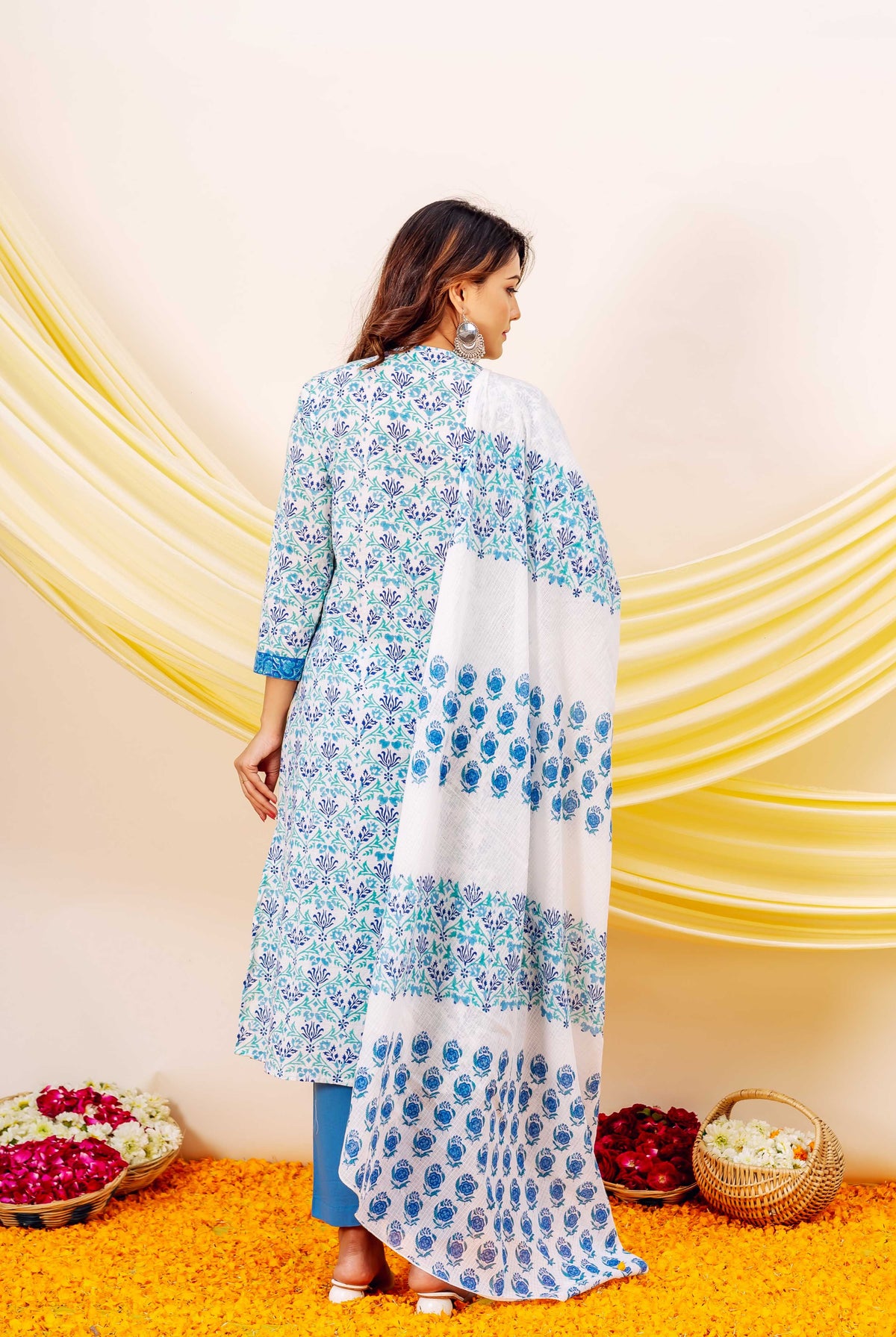 Rear view model in white and blue hand-block printed floral kurta and matching dupatta.
