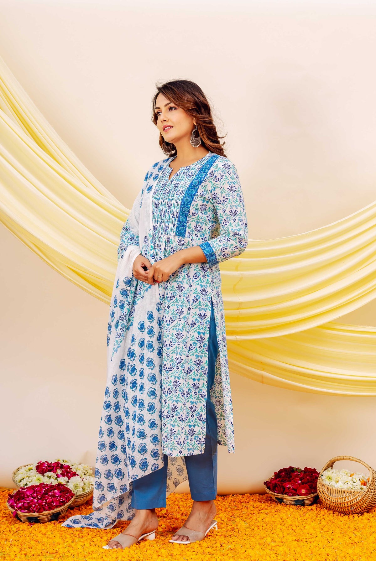 Model in full-length white cotton kurta set with blue and green block print floral motifs.