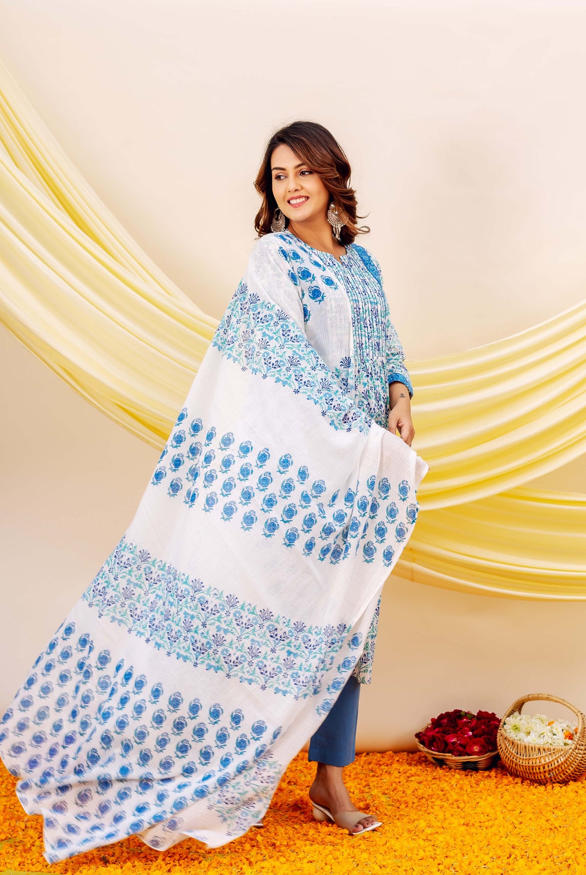 Model wearing a white and blue hand-block printed kurta set with a wide, flowing dupatta.