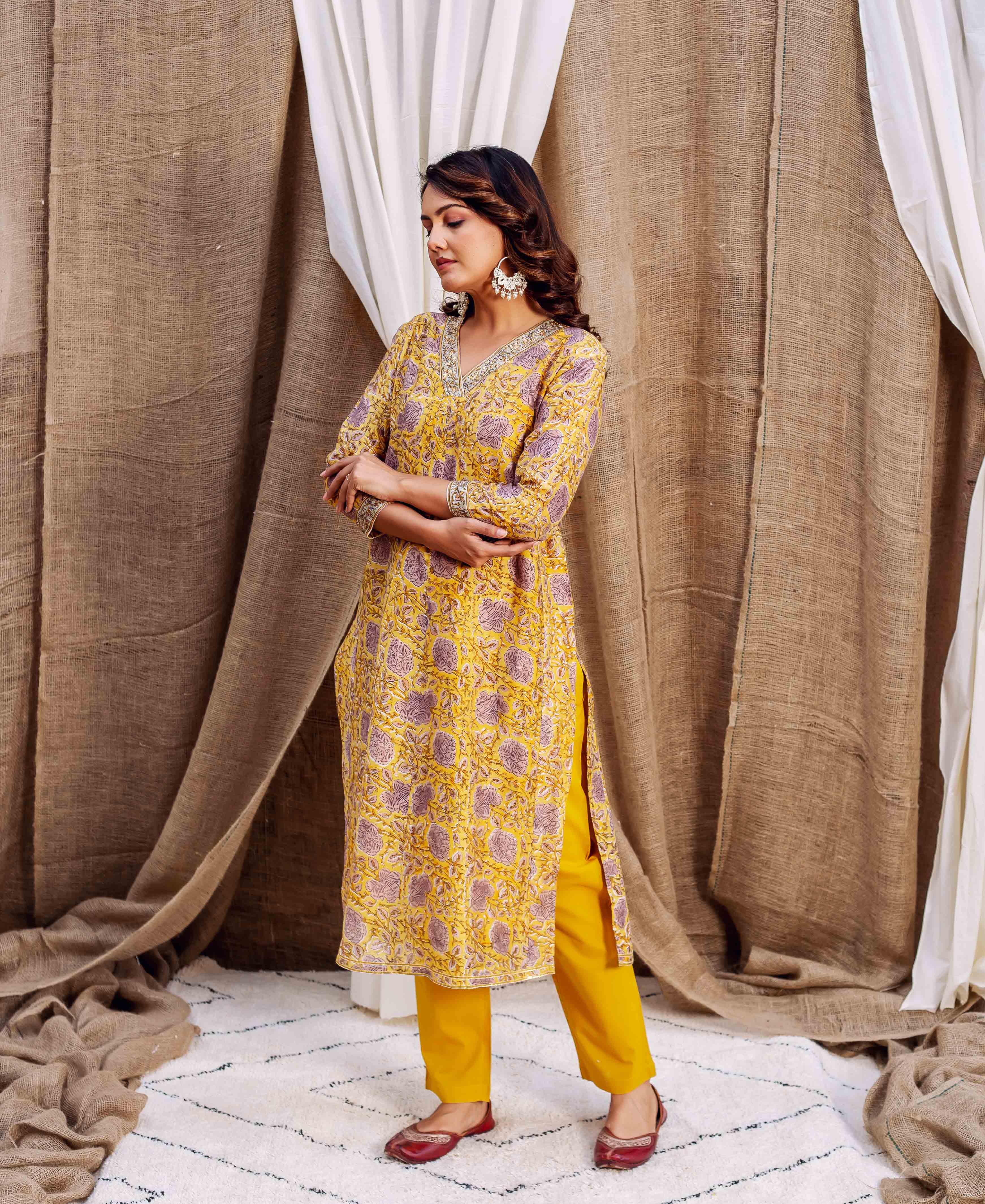 Model wearing a yellow hand-block printed Chanderi kurta with purple floral motifs and V-neck.