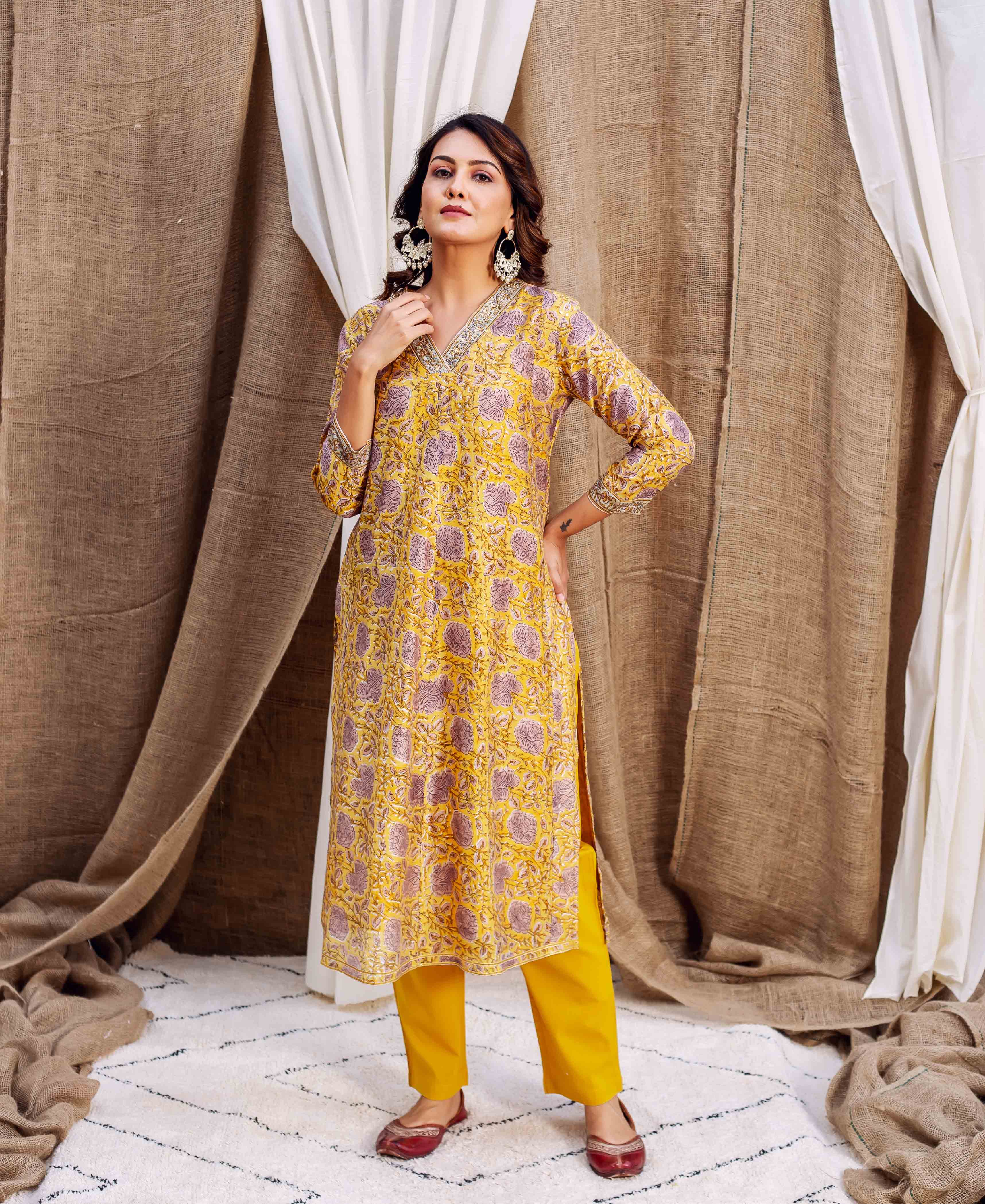 Model in a yellow kurta with purple floral block print and matching yellow pants.