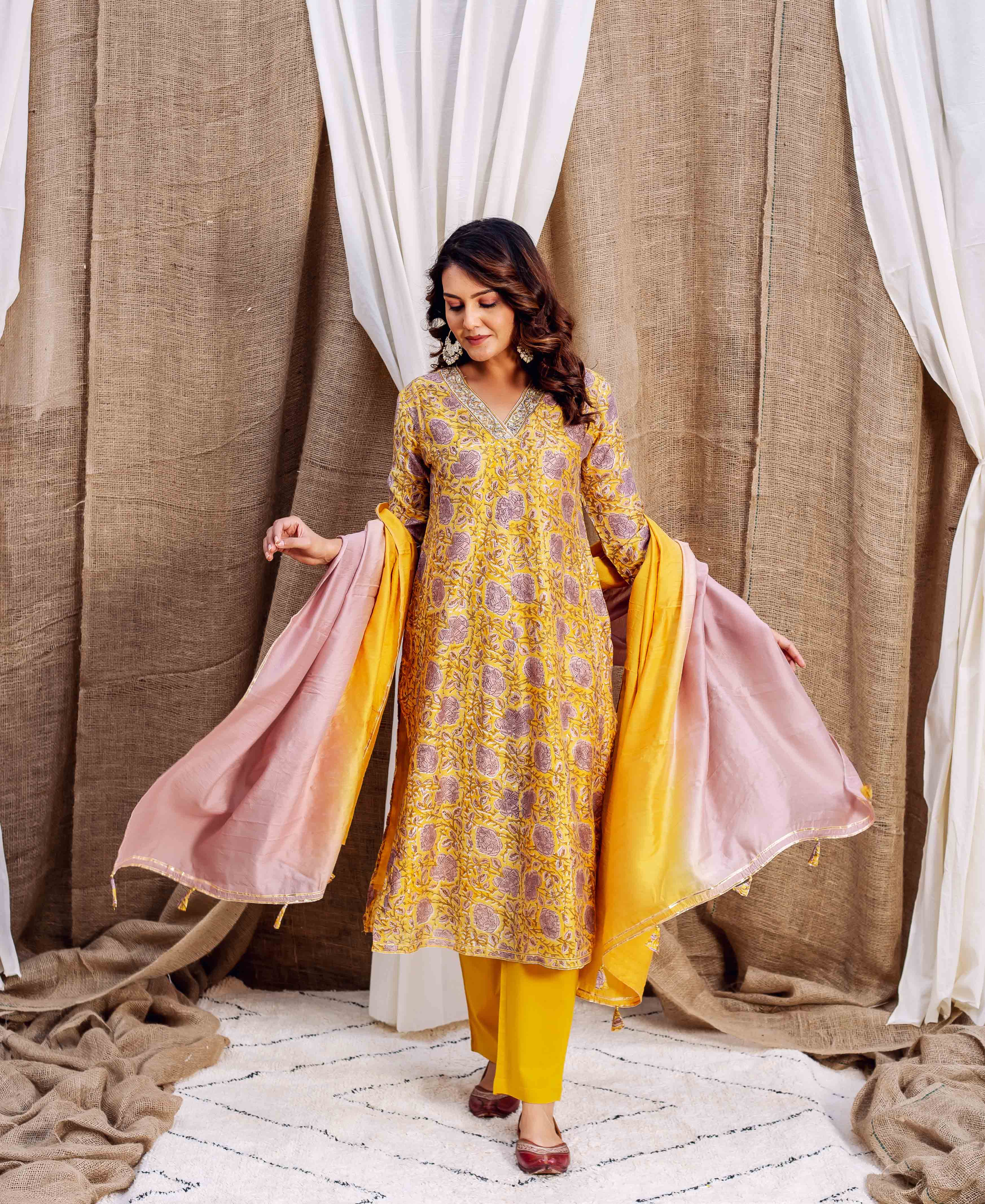 Woman wearing yellow Chanderi kurta with purple floral print and ombre dupatta.
