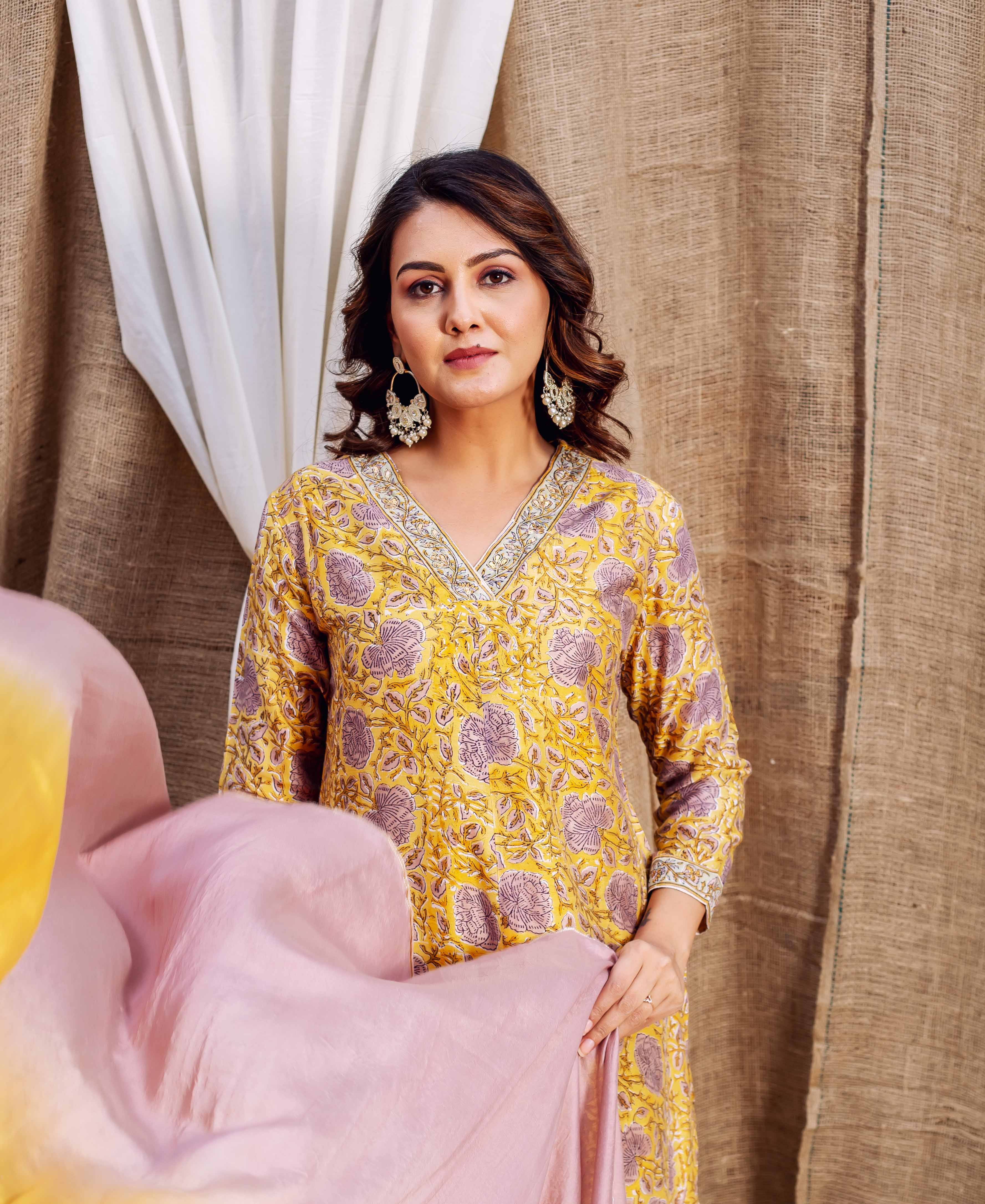 Model showcases yellow hand-block printed Chanderi kurta with vibrant purple floral designs, front.