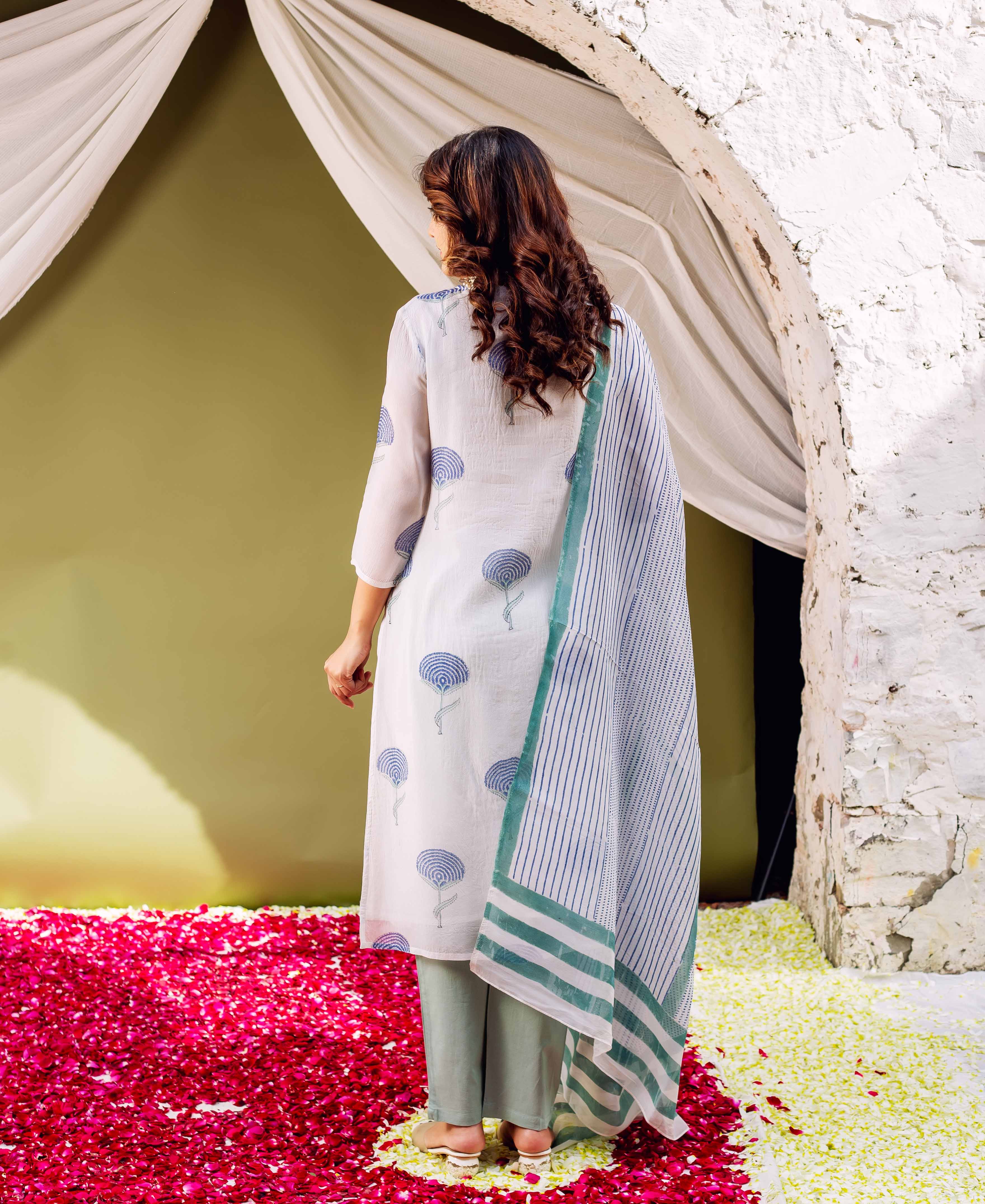 Model's back: White hand-block printed organza kurta with blue motifs, sage pants, and striped dupatta.