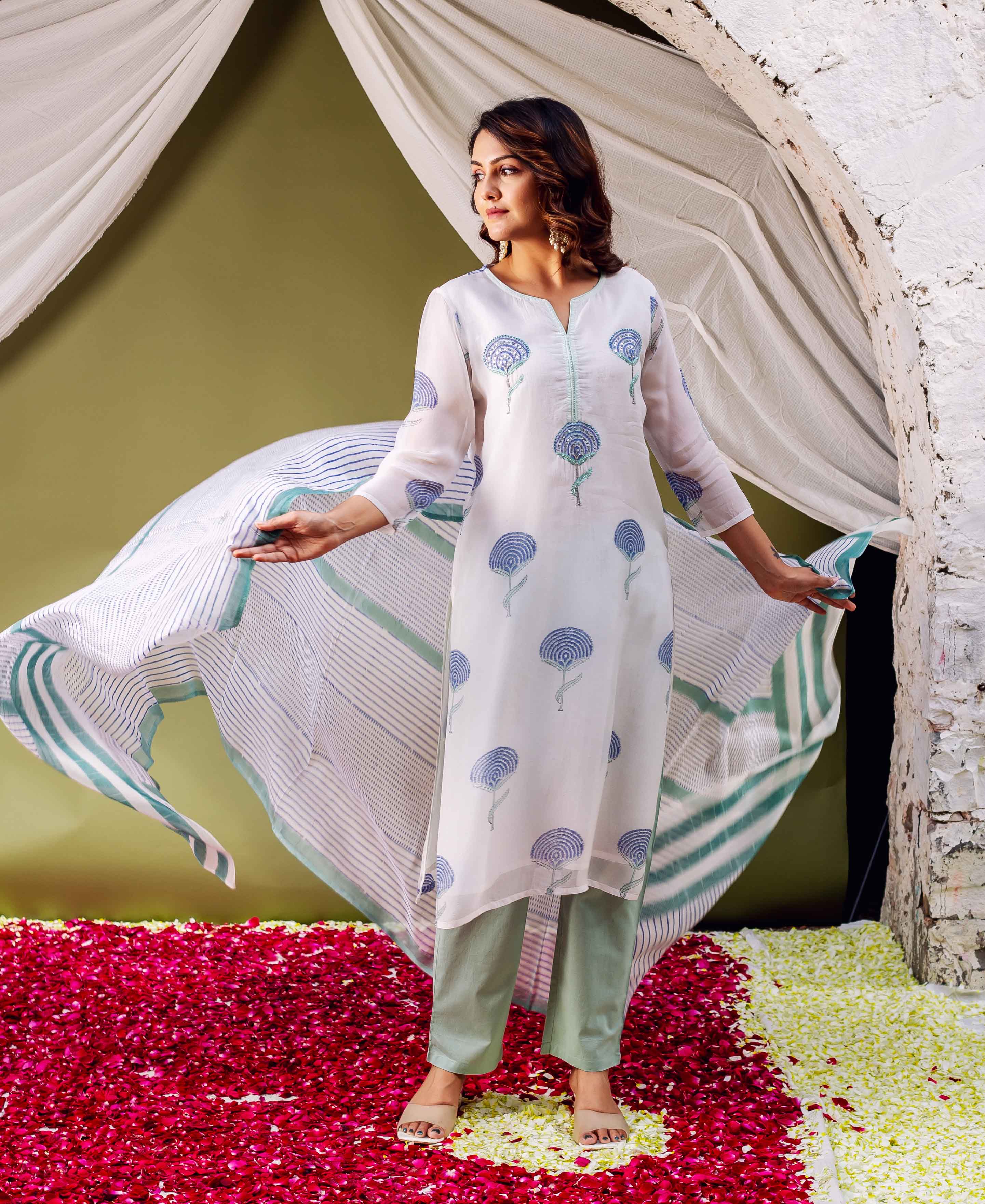 Model in white hand-block printed organza kurta with blue motifs, sage pants, and striped dupatta.