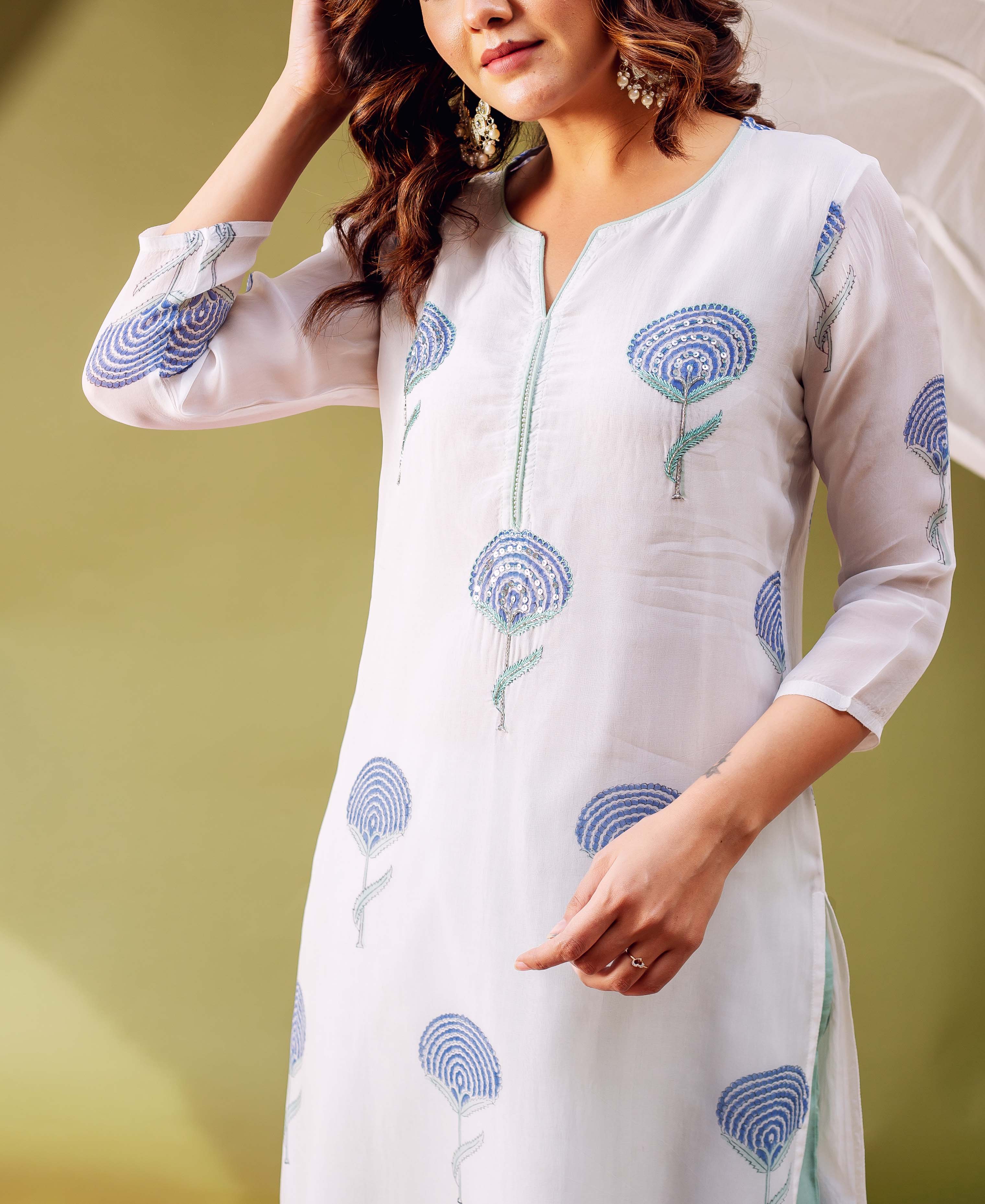 Close-up of a model wearing a white hand block printed organza kurta with blue floral designs.
