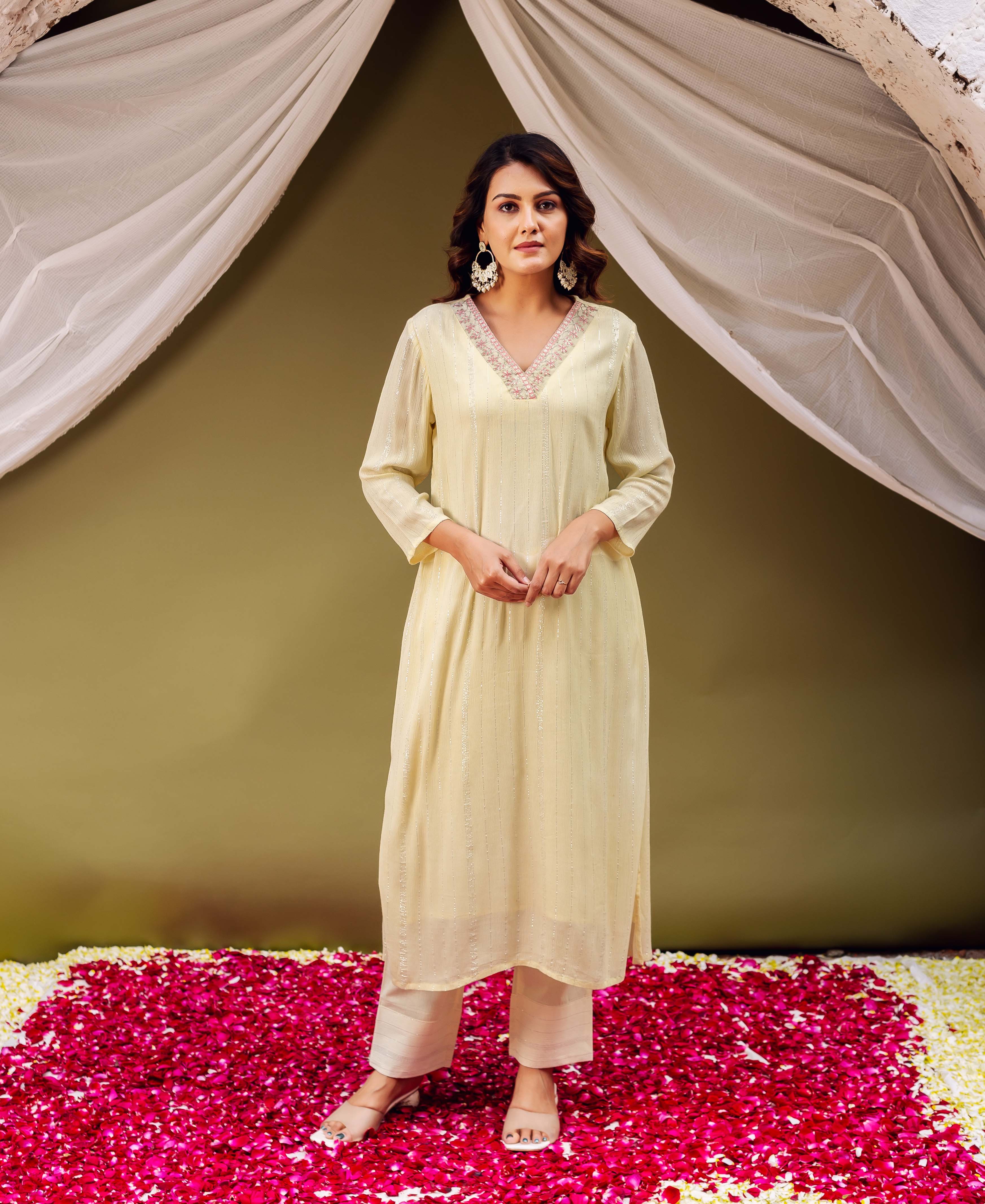 Lemon yellow embroidered kurta with subtle vertical stripes worn by a model, paired with beige pants.