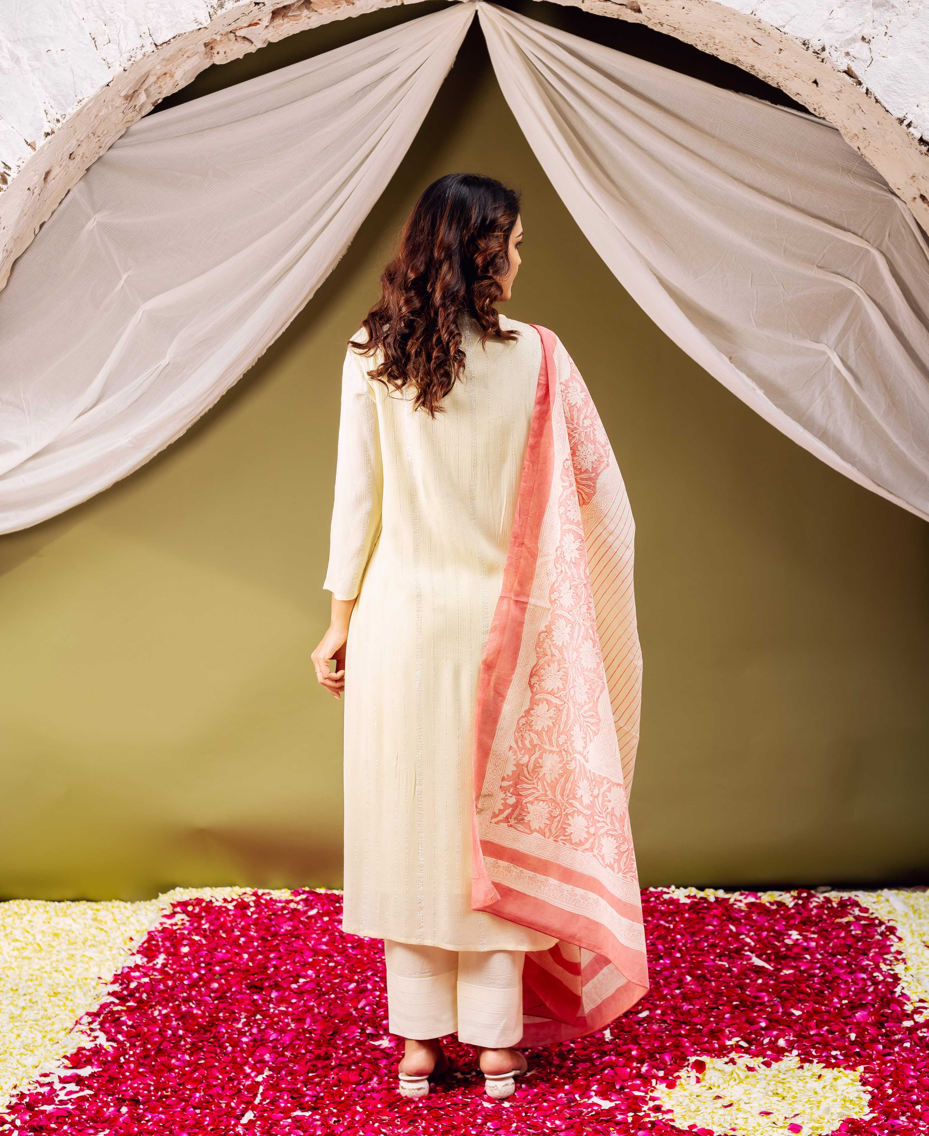 Back view model in lemon yellow embroidered kurta, flowing pink hand-block printed dupatta.