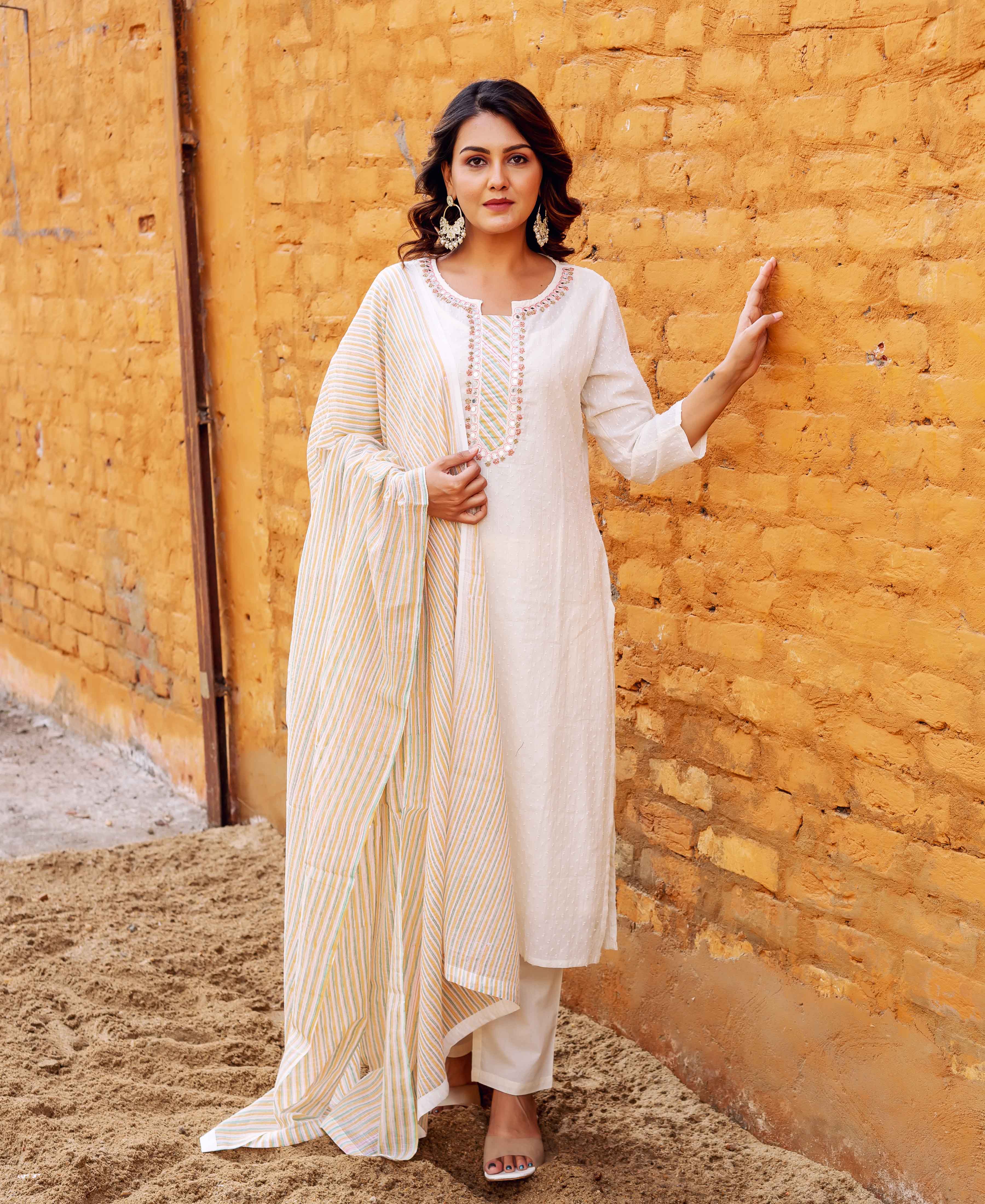 Full shot of woman in an ivory jacquard kurta with embroidered neckline and striped dupatta.