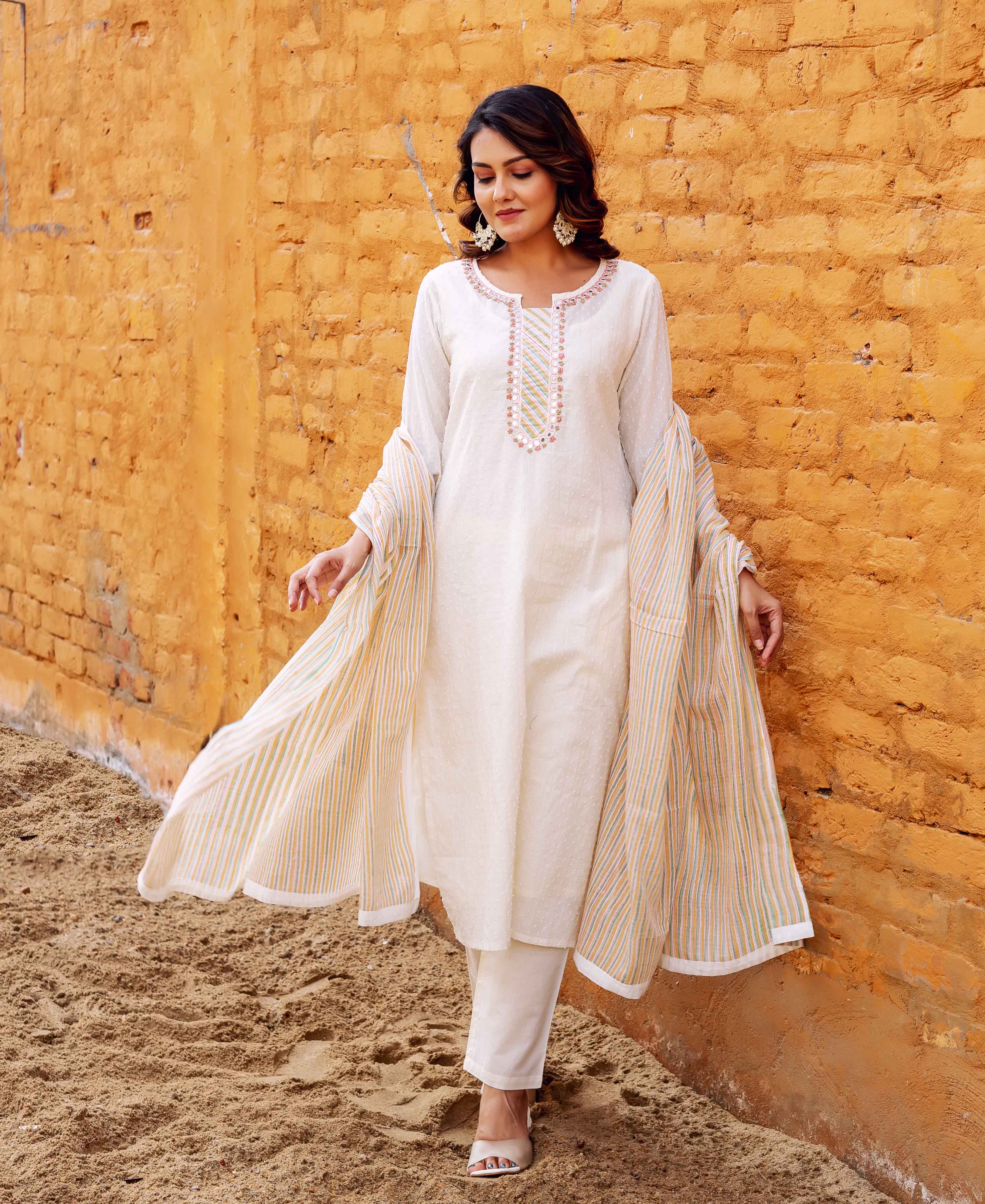 Model poses in an ivory jacquard kurta with an embroidered neckline and striped dupatta.