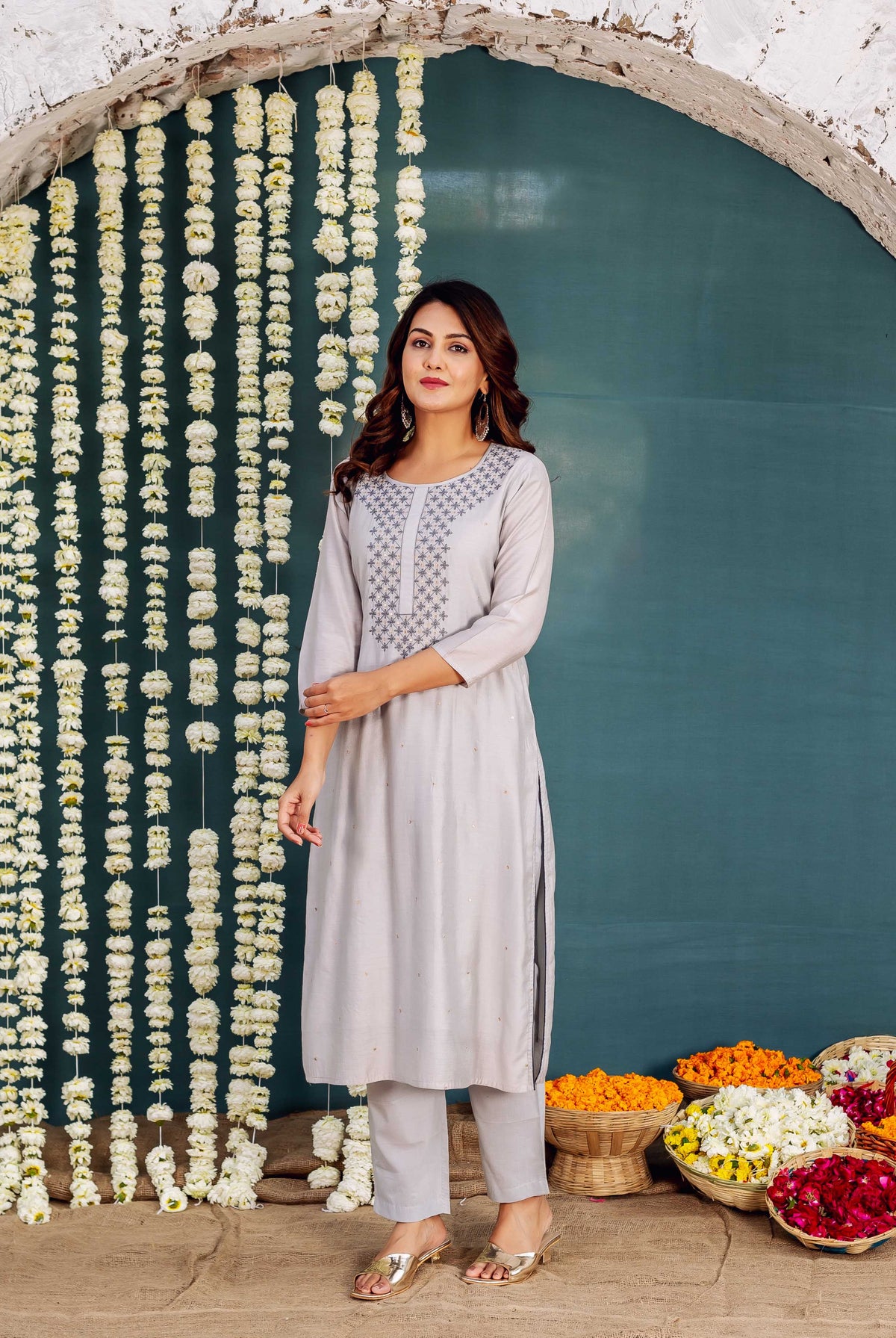 Model wears a light grey embroidered kurta with dark geometric patterns on the yoke.