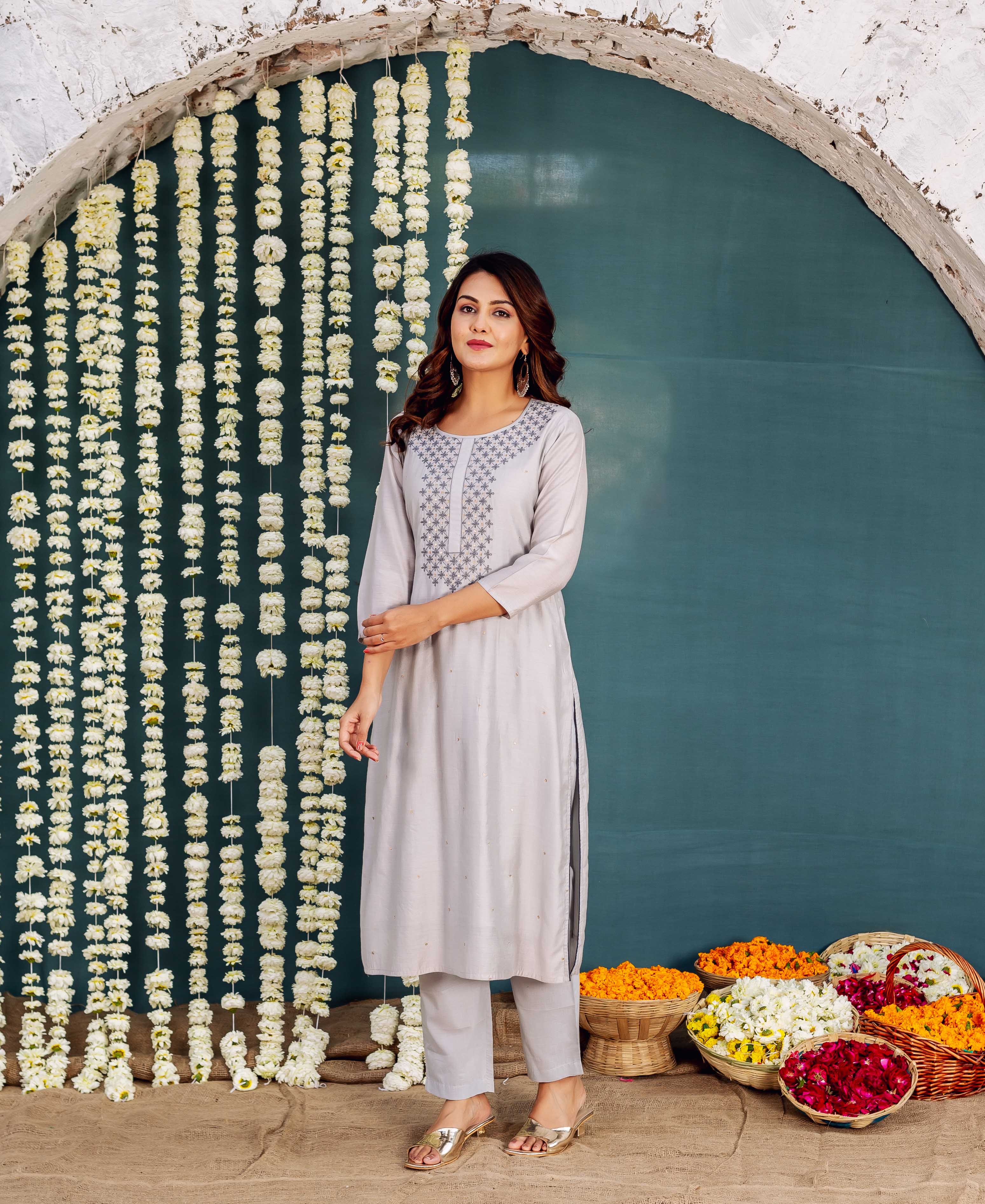Model wears a light grey embroidered kurta with dark geometric patterns on the yoke.