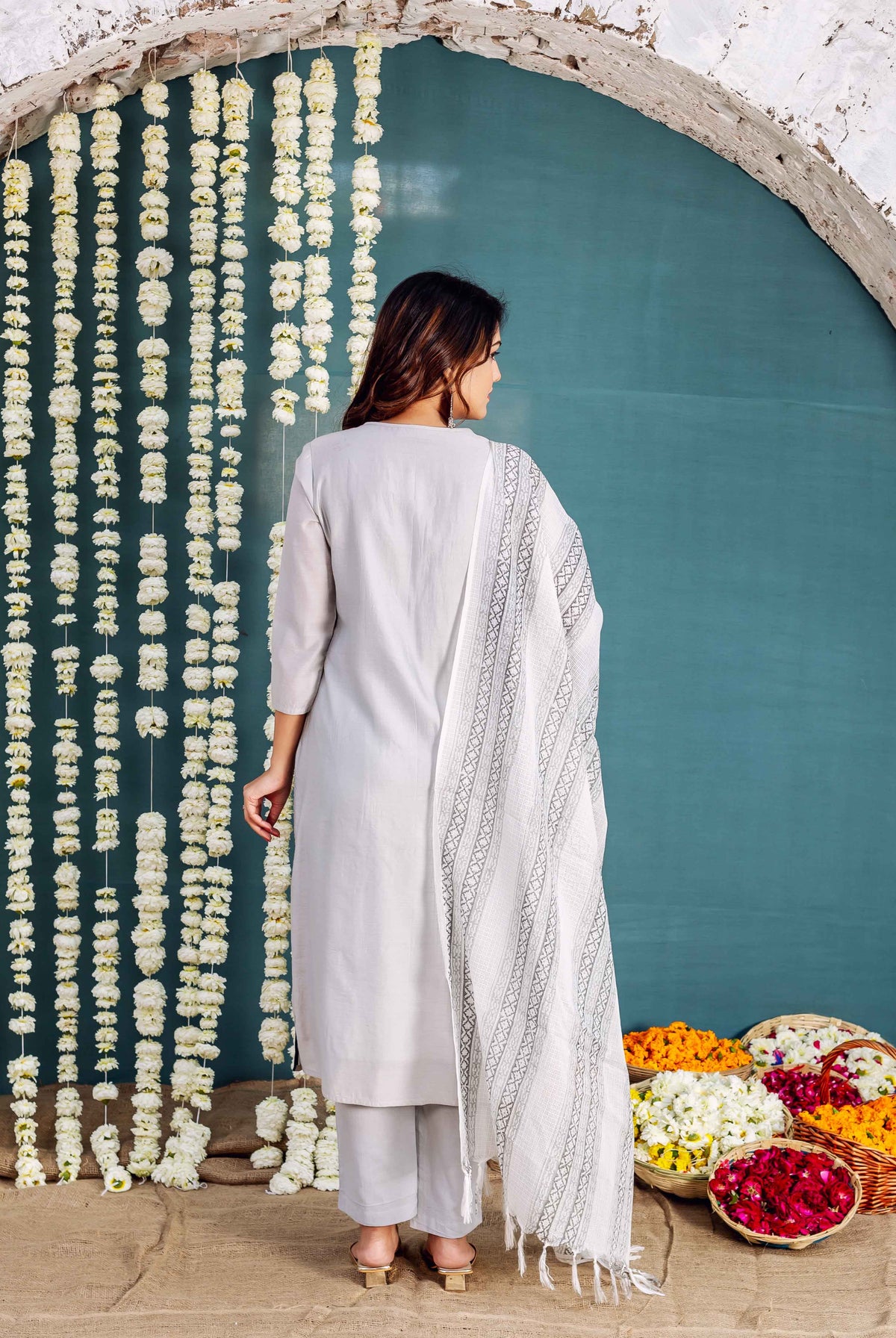 Back view of a model wearing a simple grey kurta with a white geometric printed dupatta.