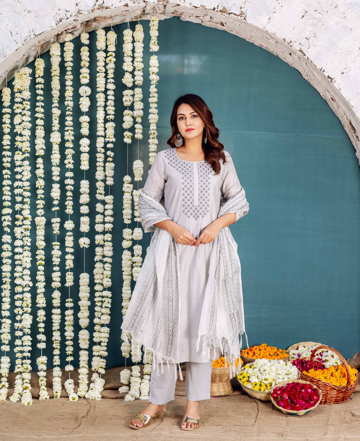 Model wears grey embroidered kurta with matching pants and hand-block-printed dupatta.